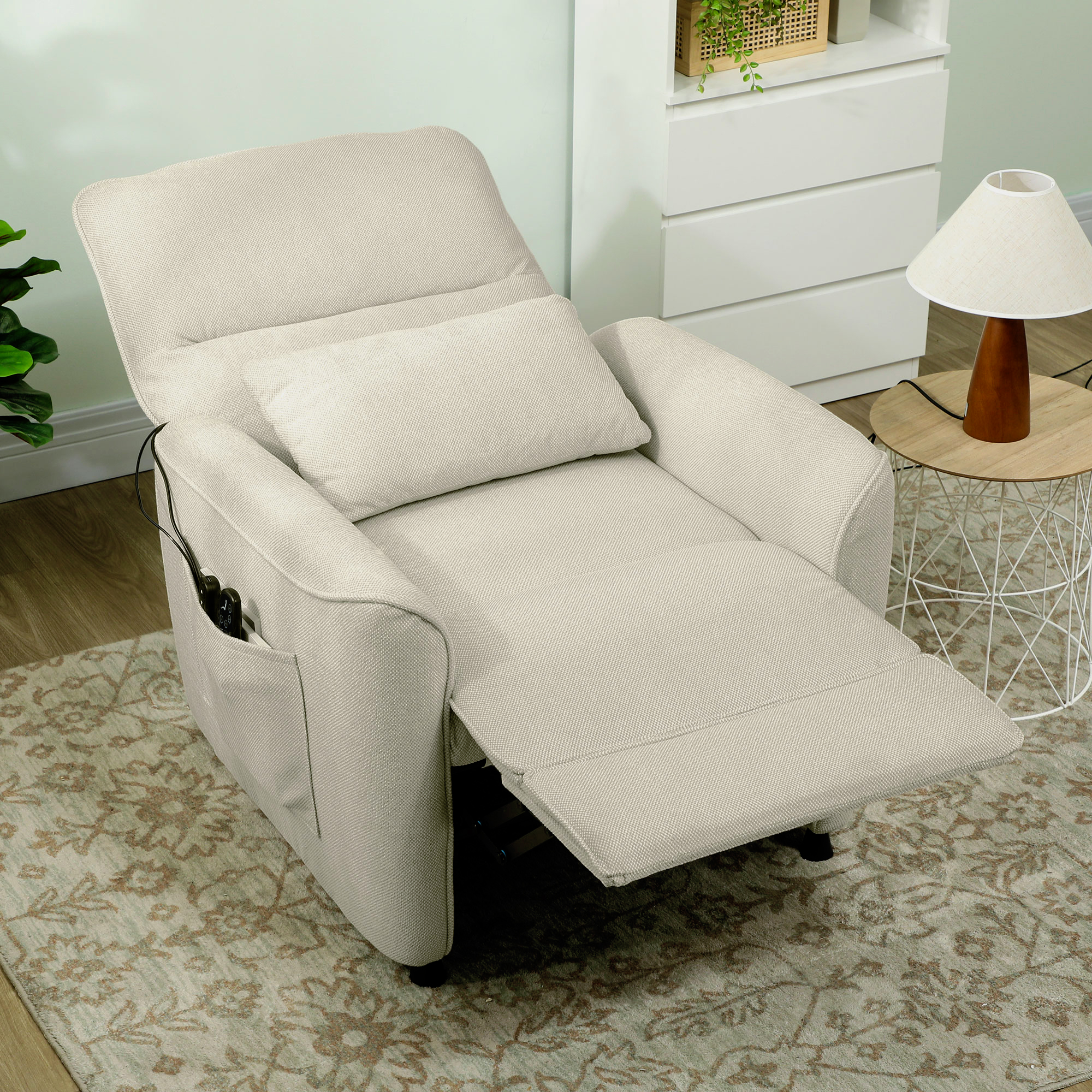 Un sillón reclinable beige con reposapiés y cojín está sobre una alfombra.
