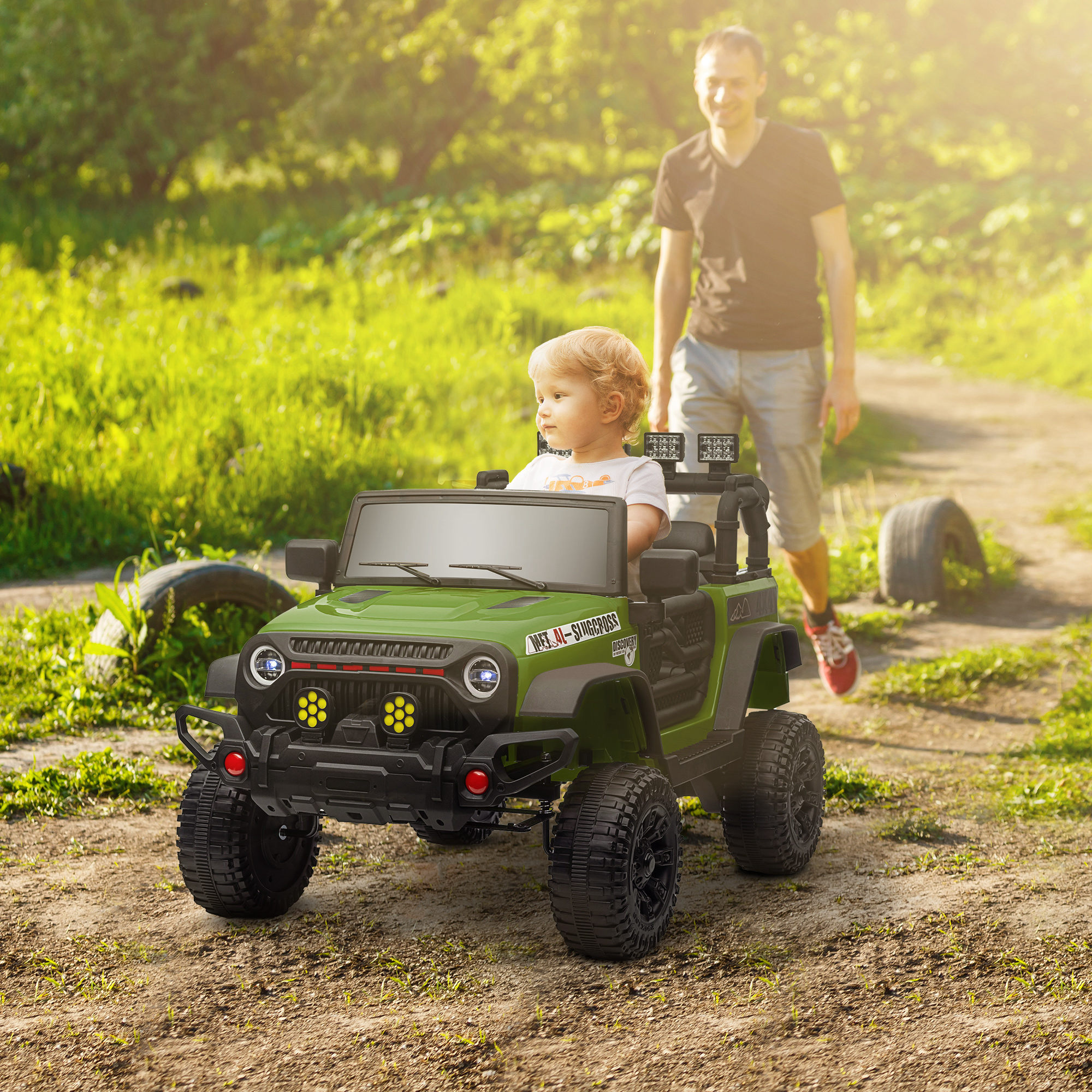 Un niño conduce un jeep de juguete verde, un hombre camina detrás.