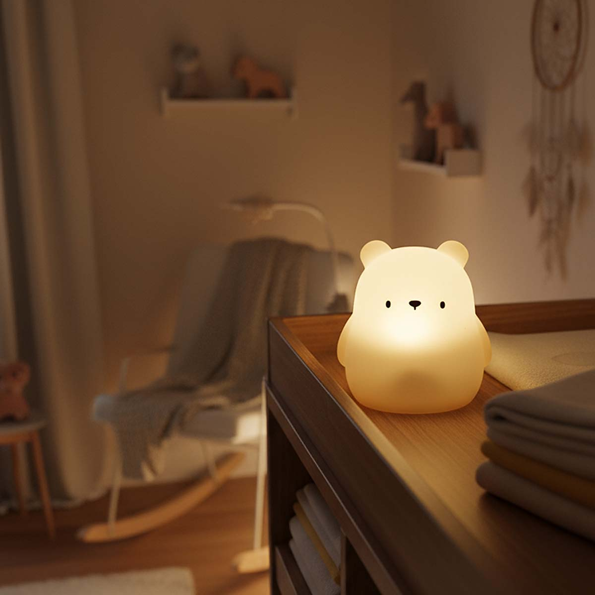 Ein leuchtender Teddybär auf einem Nachttisch in einem Kinderzimmer.