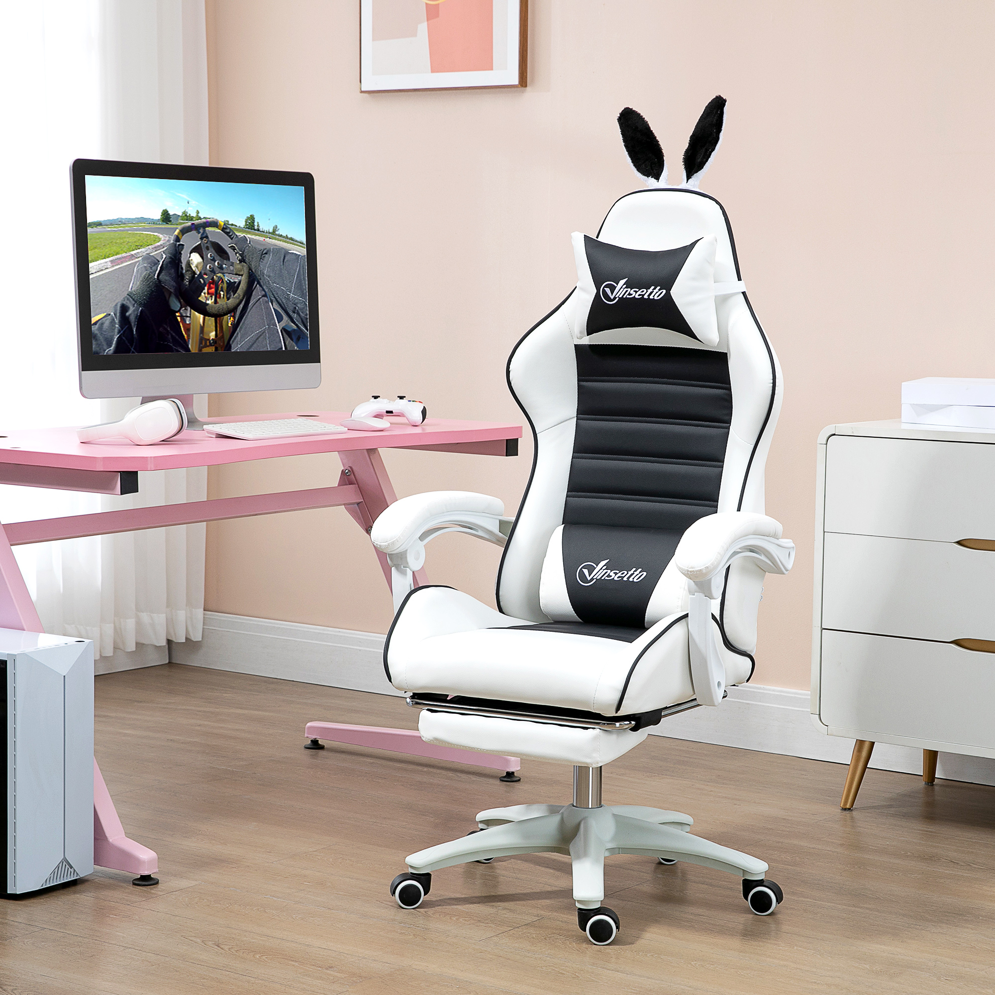 Sedia da gaming bianca e nera con orecchie da coniglio, scrivania rosa con computer e mobile bianco.
