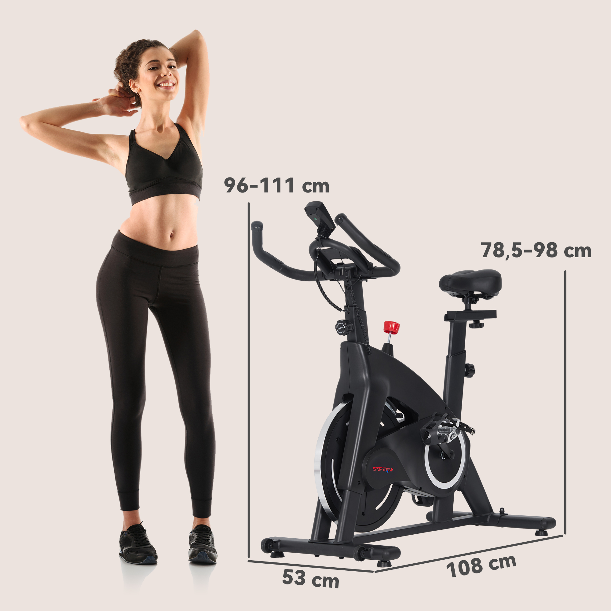 Una mujer con ropa deportiva junto a una bicicleta estática negra con dimensiones.