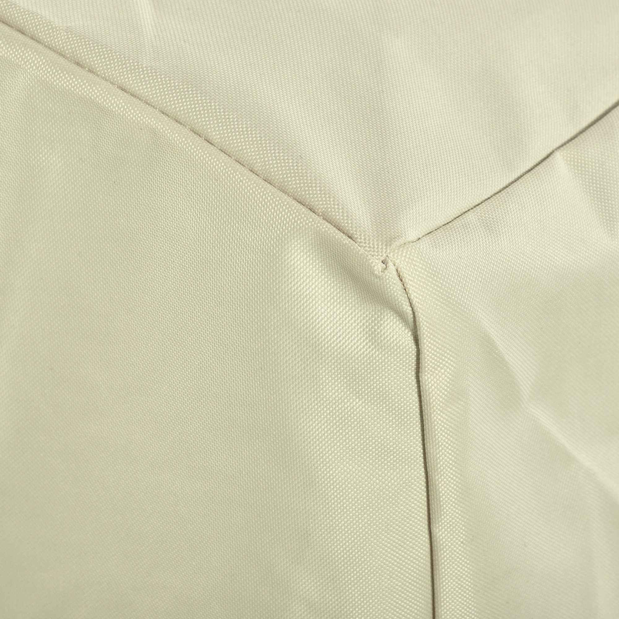 Detalles de costura en tela beige claro formando un bloque geométrico.
