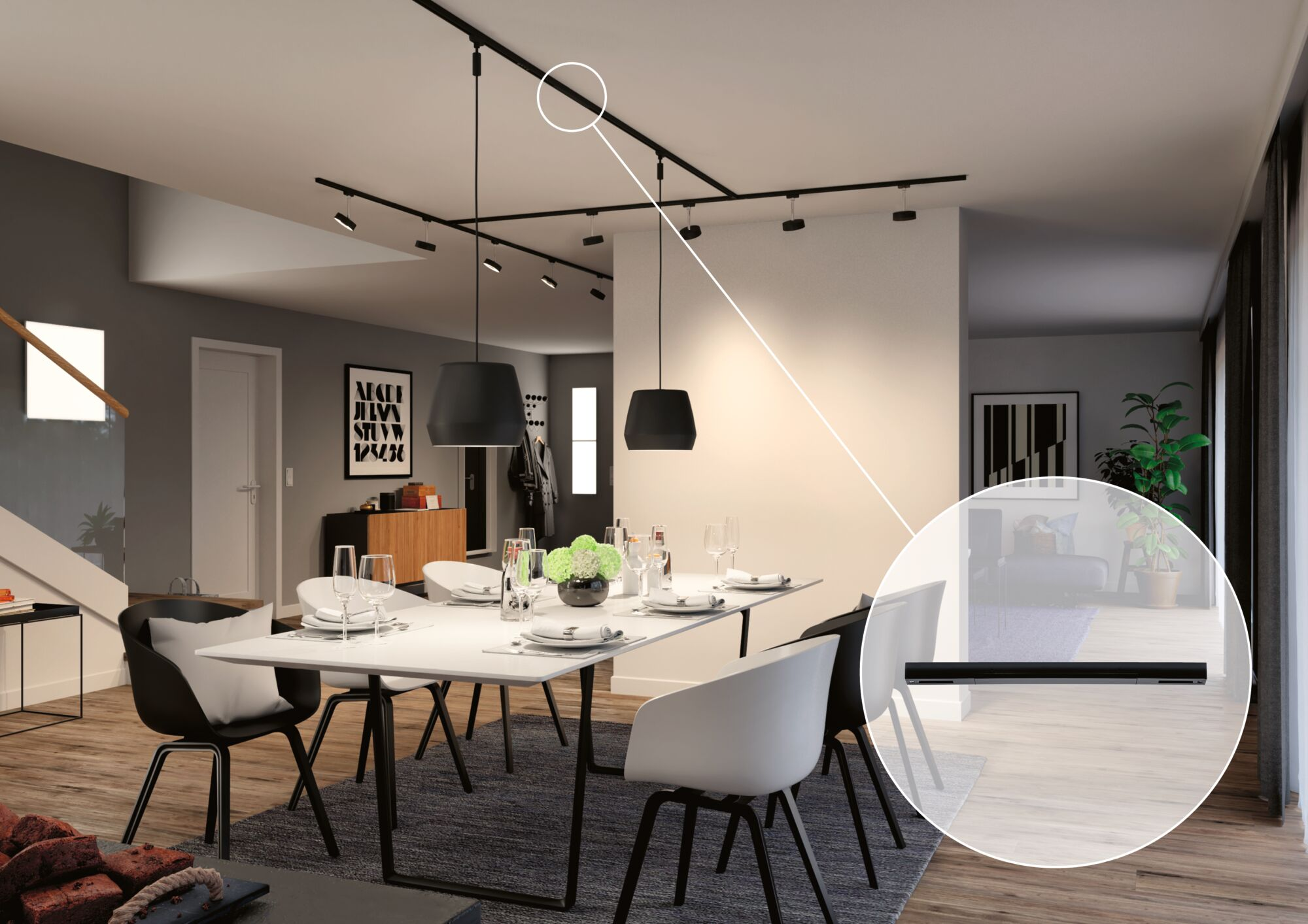 Ein Esszimmer mit einem weißen Tisch, schwarzen und weißen Stühlen und einer Schienenbeleuchtung.