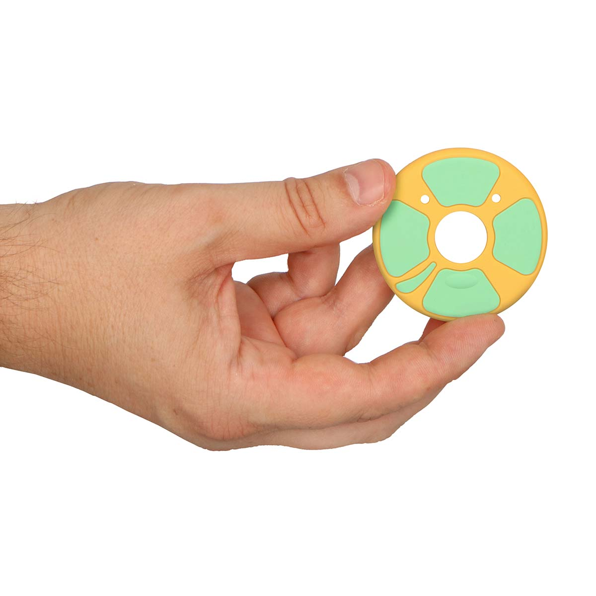A hand holds a yellow ring with green accents and a hole in the center.