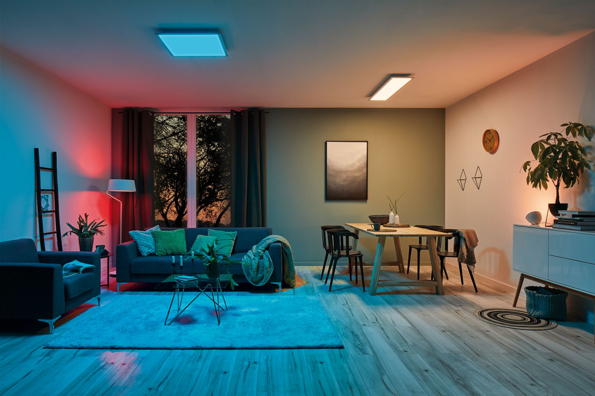 Wohnzimmer mit Sofa, Esstisch und farbiger Beleuchtung.