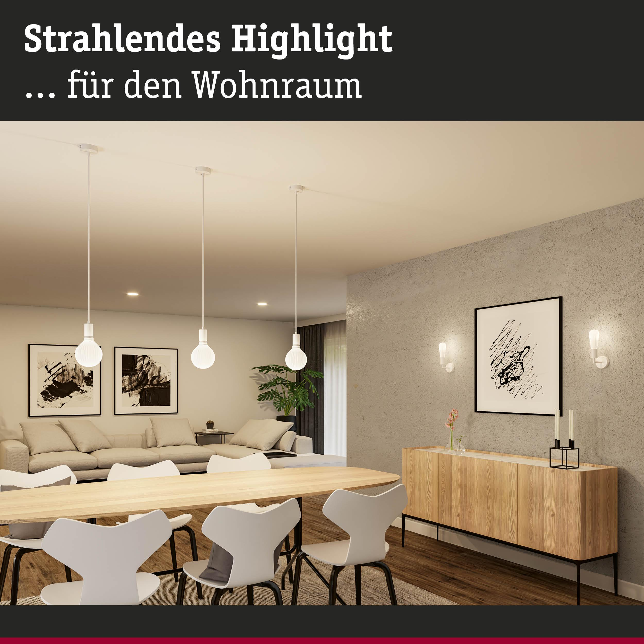 Jadalnia z nowoczesnym stołem, białymi krzesłami i salonem w tle.