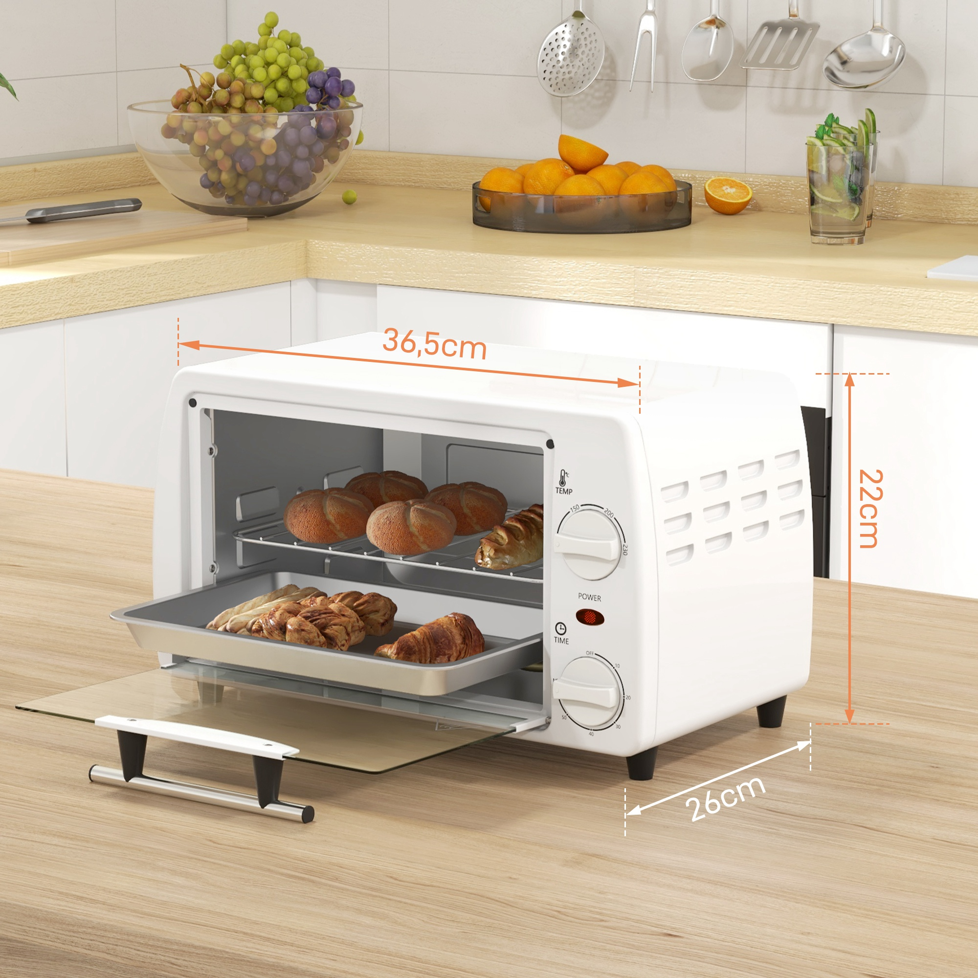 Un horno de sobremesa blanco con pasteles en una rejilla y bandeja.