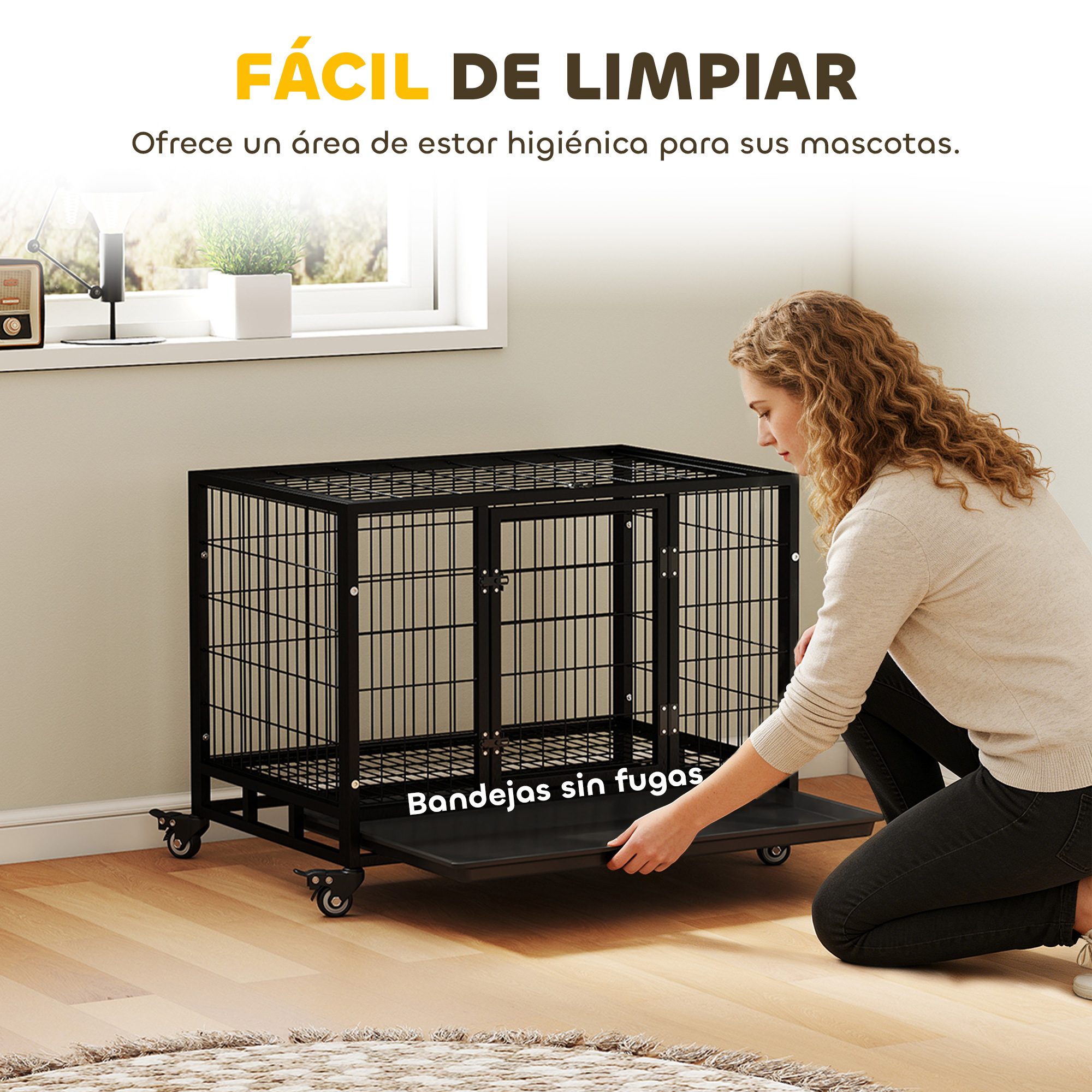 Una mujer saca un cajón debajo de una jaula para perros negra.