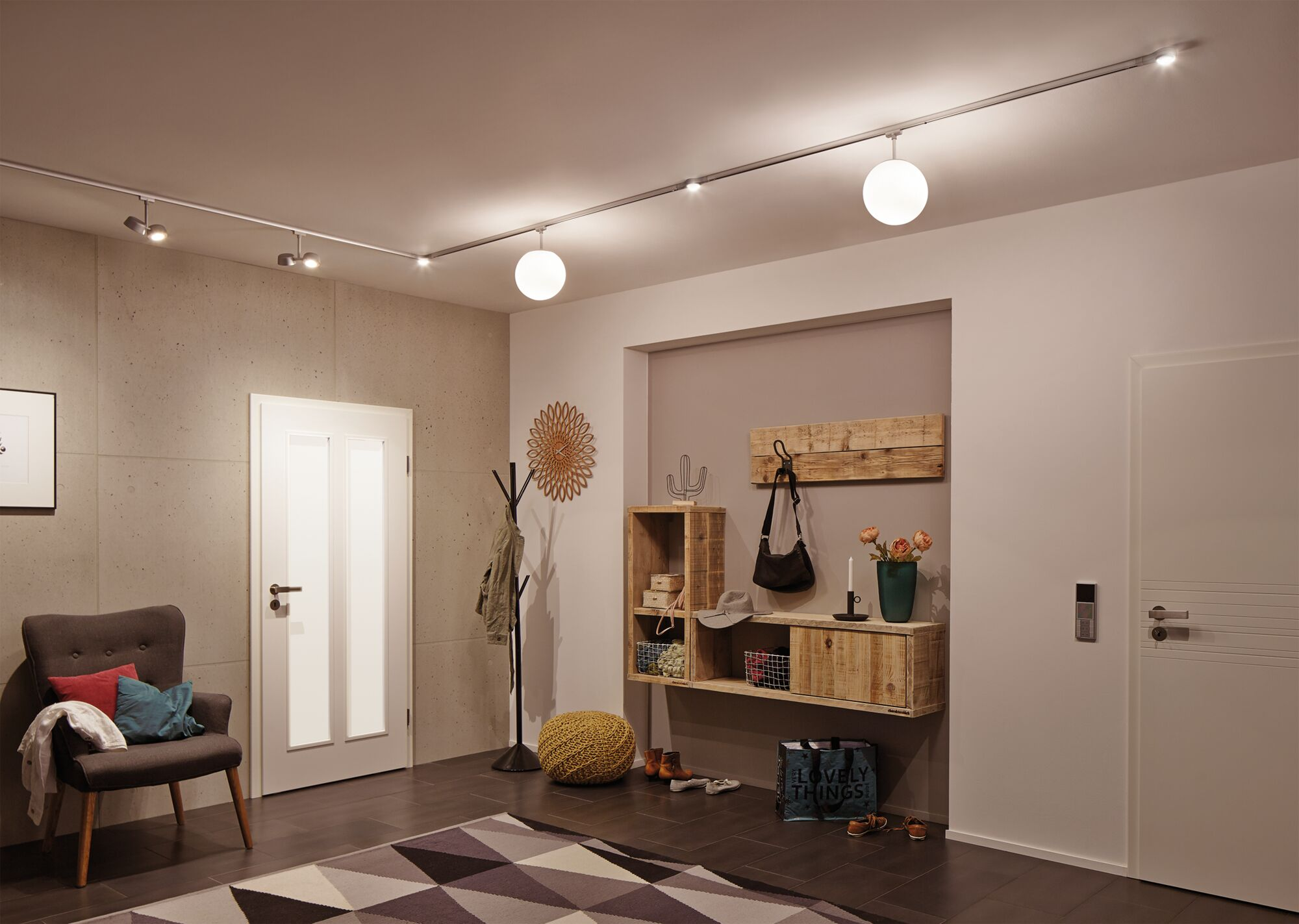 Ein Flur mit einem Sessel, Garderobe, Regal und Türen.