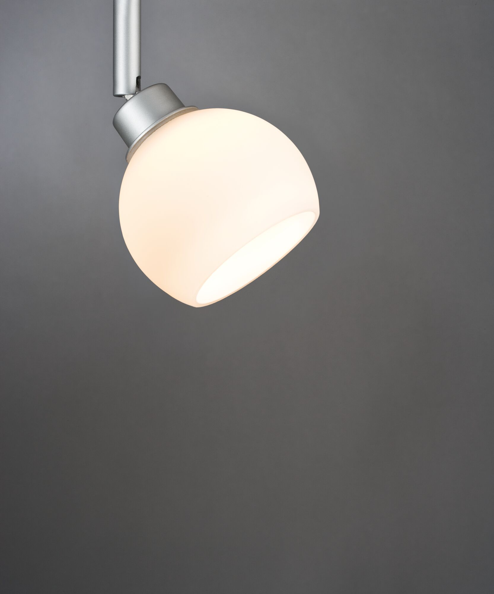 Eine weiße Glaskugel-Lampe mit silbernem Gelenk auf grauem Hintergrund.
