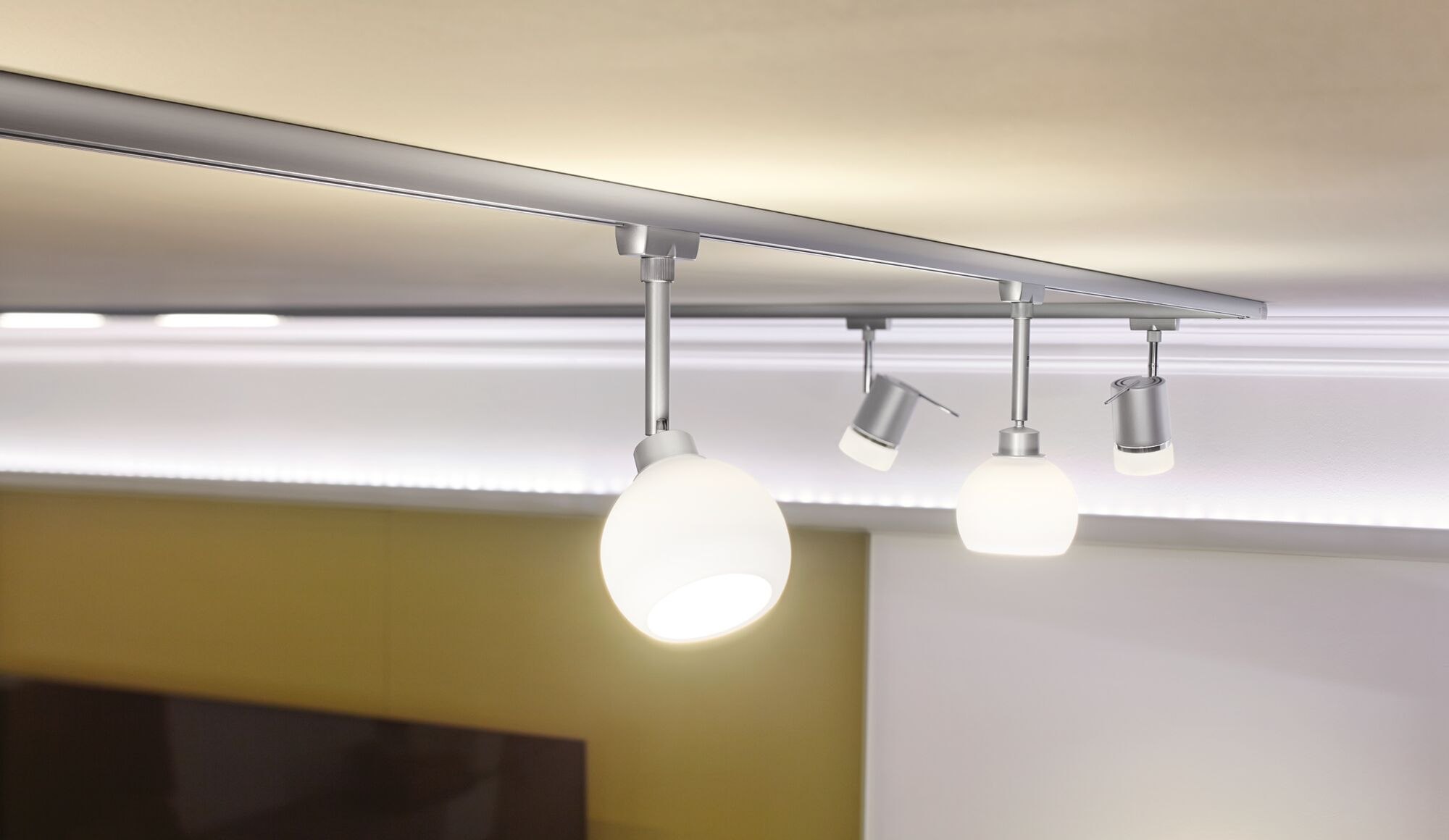 Eine silberne Schienenbeleuchtung mit mehreren kugelförmigen Lampen an der Decke.