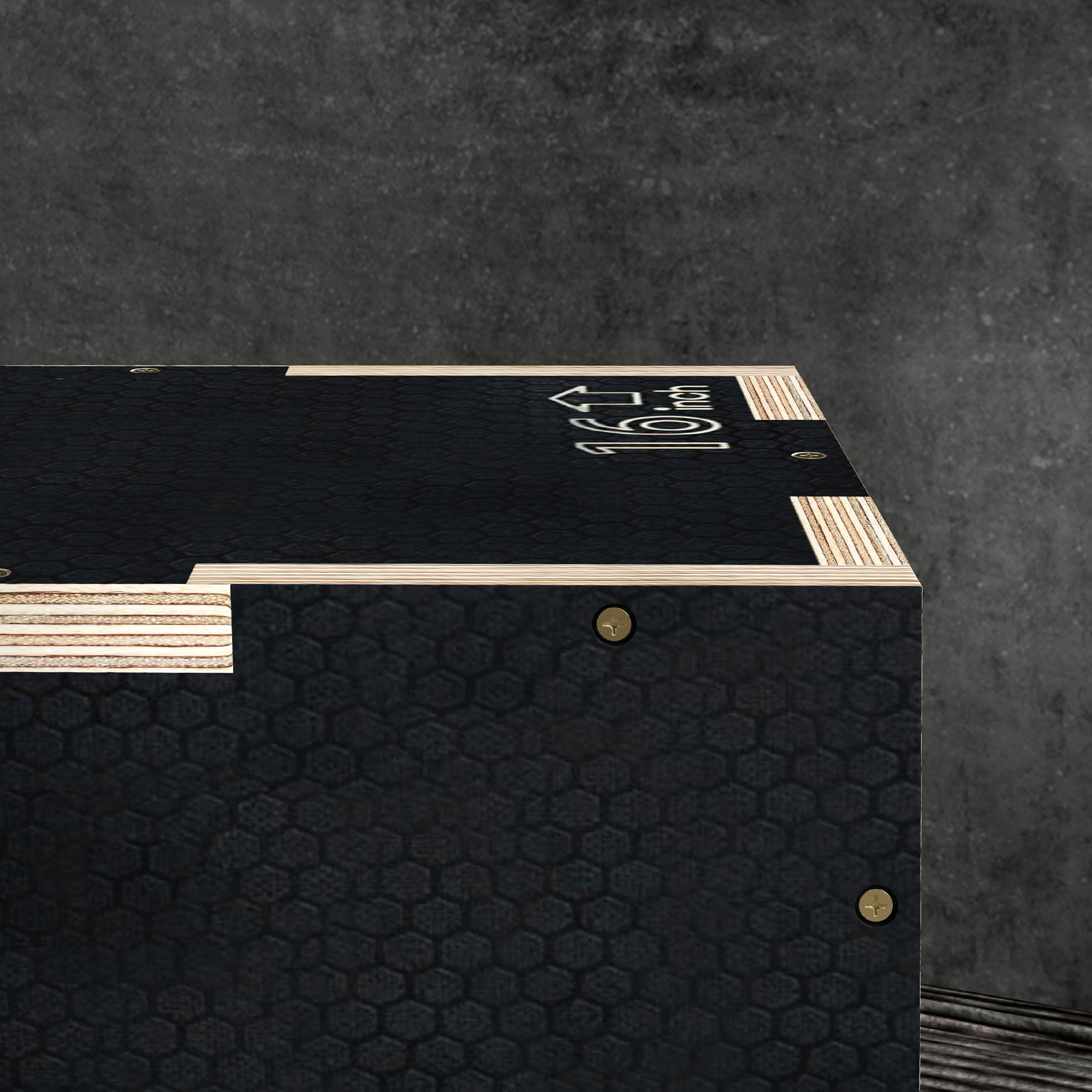 Caja negra con estampado de panal, bordes de madera y tornillos contra pared de hormigón.