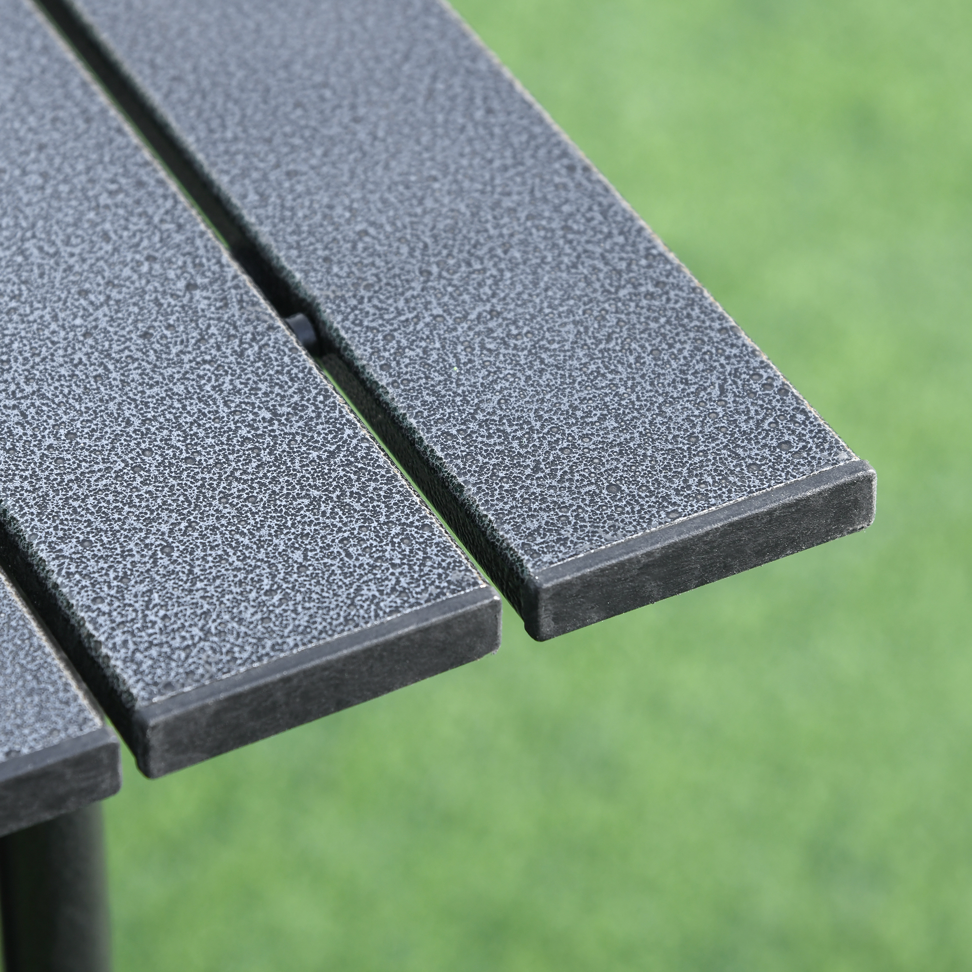 Superficie de mesa de metal gris texturizada, con fondo verde desenfocado.