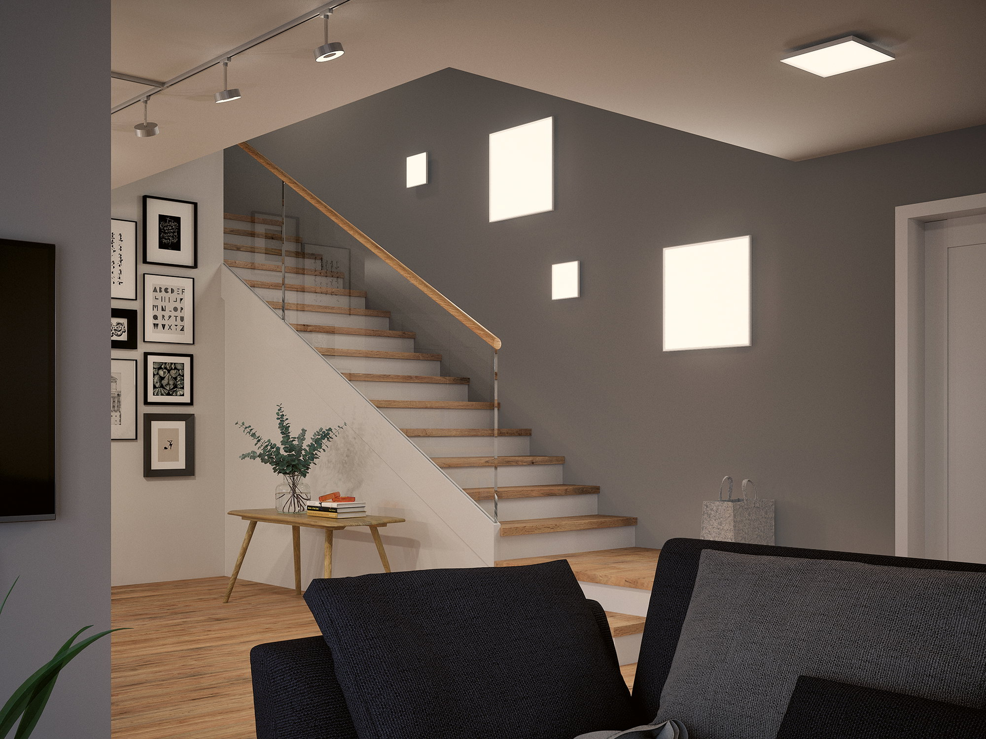 Ein moderner Wohnbereich mit Treppe, Sofa und Kunst an der Wand.