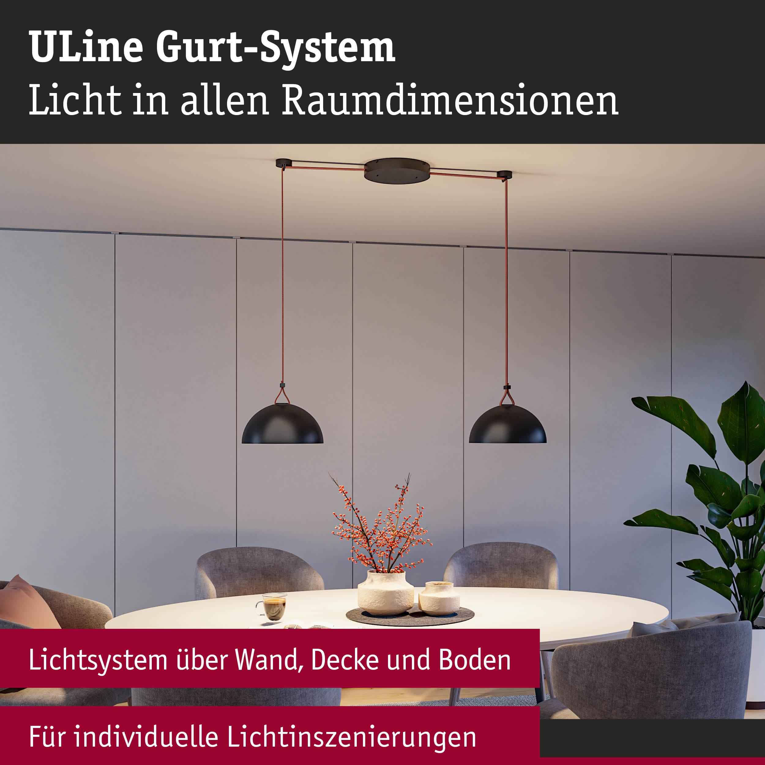 Zwei schwarze Pendelleuchten hängen über einem Esstisch mit Deko und Stühlen.