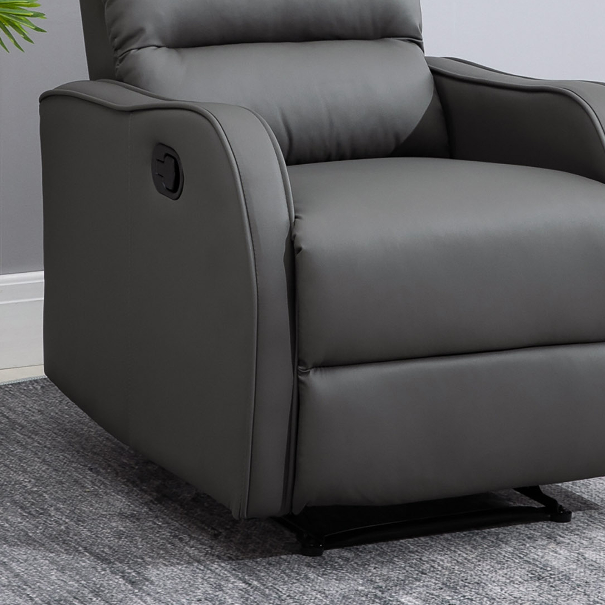 Sillón reclinable gris con asa negra en el lateral, sobre alfombra gris.