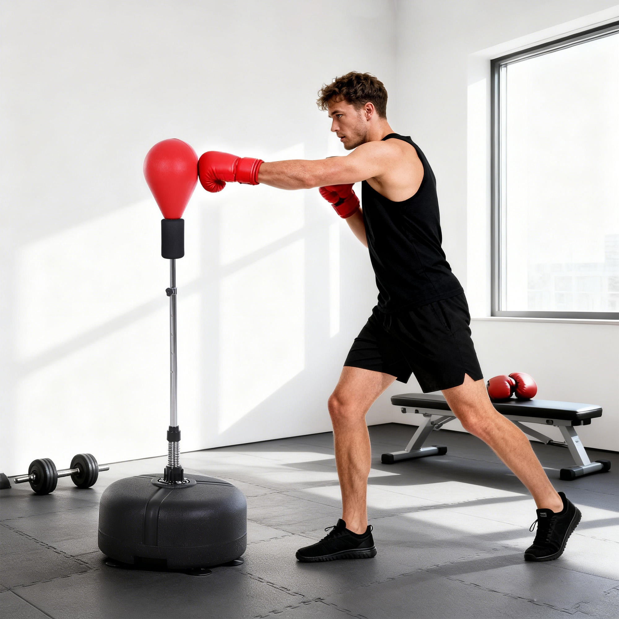 Un hombre con guantes de boxeo rojos entrena en un saco de boxeo rojo en un gimnasio.