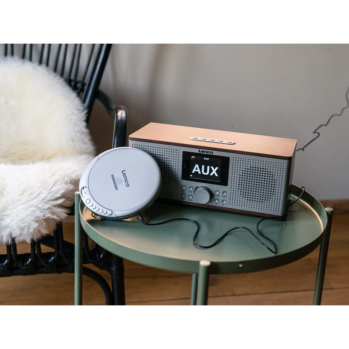 Odtwarzacz CD Lenco i radio stoją na stole obok krzesła.