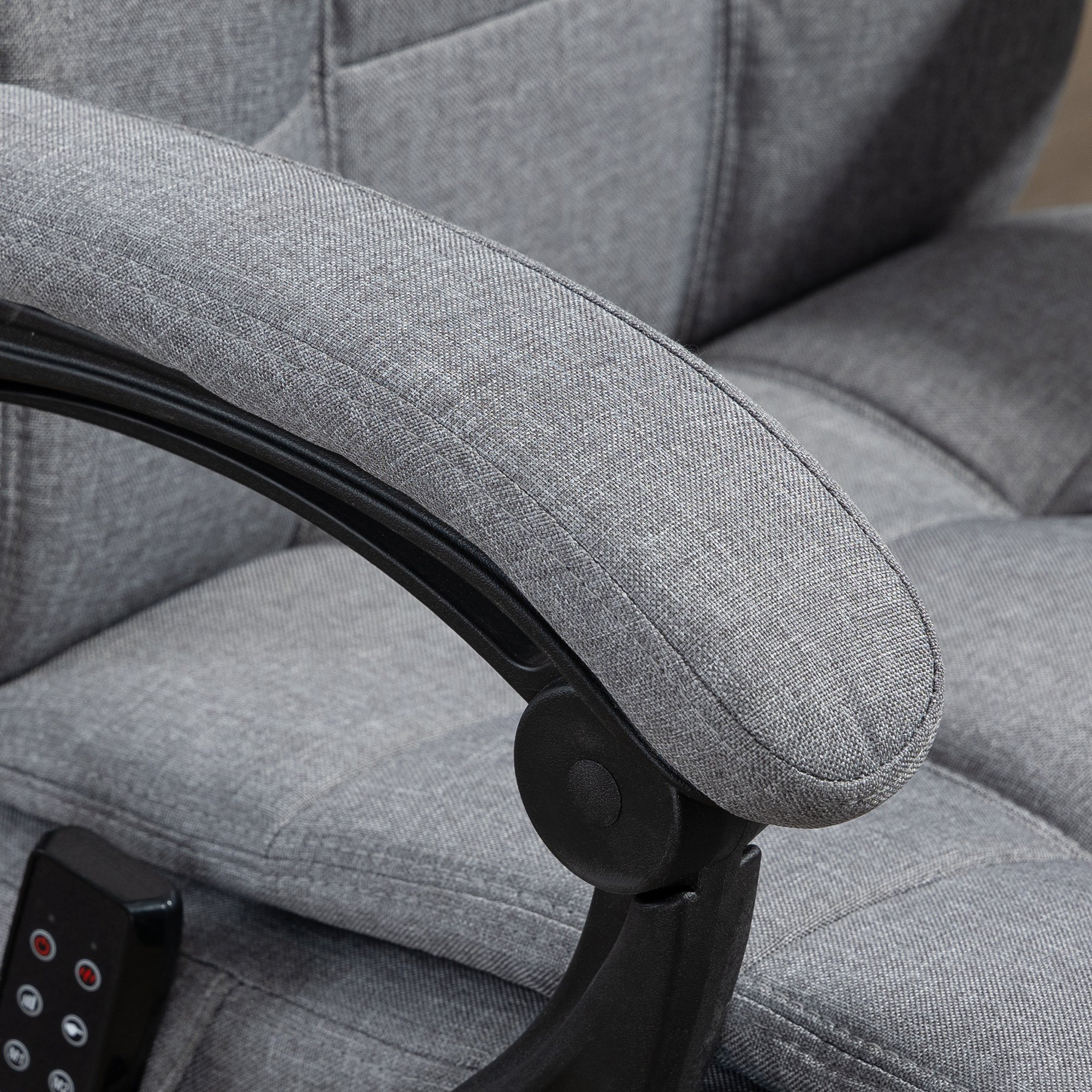 Reposabrazos de sillón de tela gris con marco de plástico negro y mando.