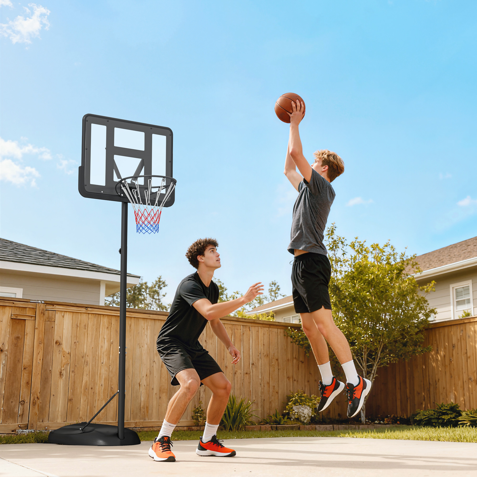 Dos chicos juegan al baloncesto en un patio. Uno tira, el otro defiende.