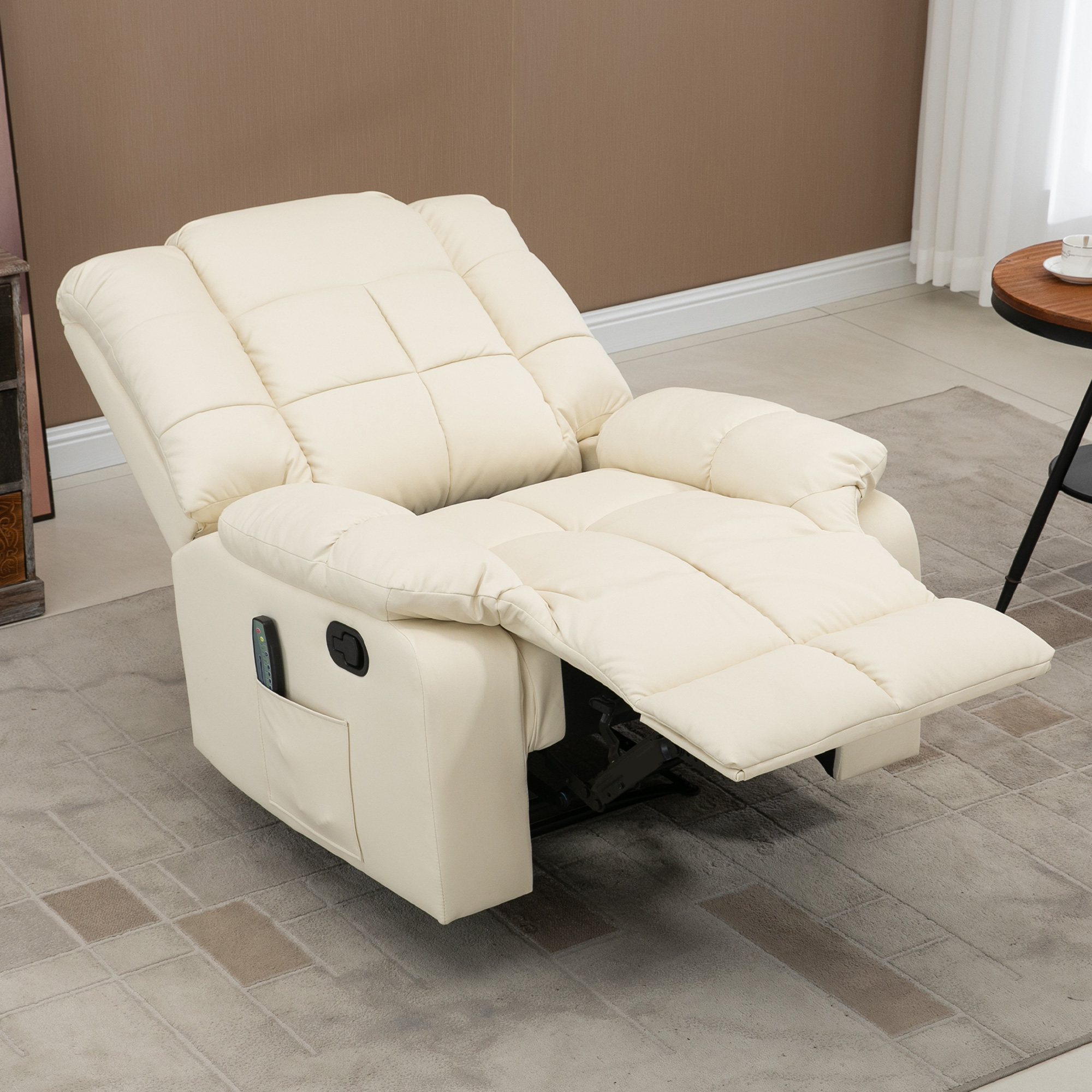 Un sillón reclinable color crema con el reposapiés extendido, sobre una alfombra estampada.