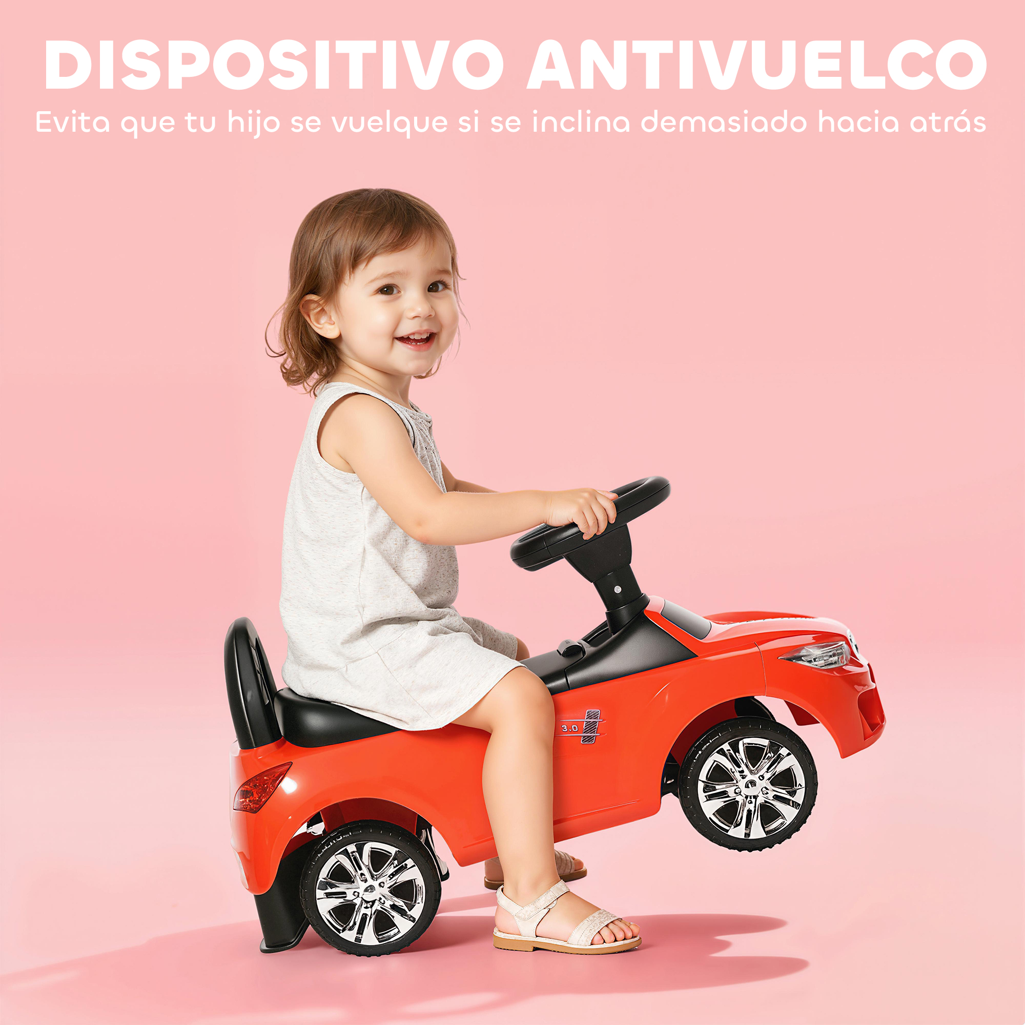 Un niño sonriente se sienta en un coche de juguete rojo sobre fondo rosa.