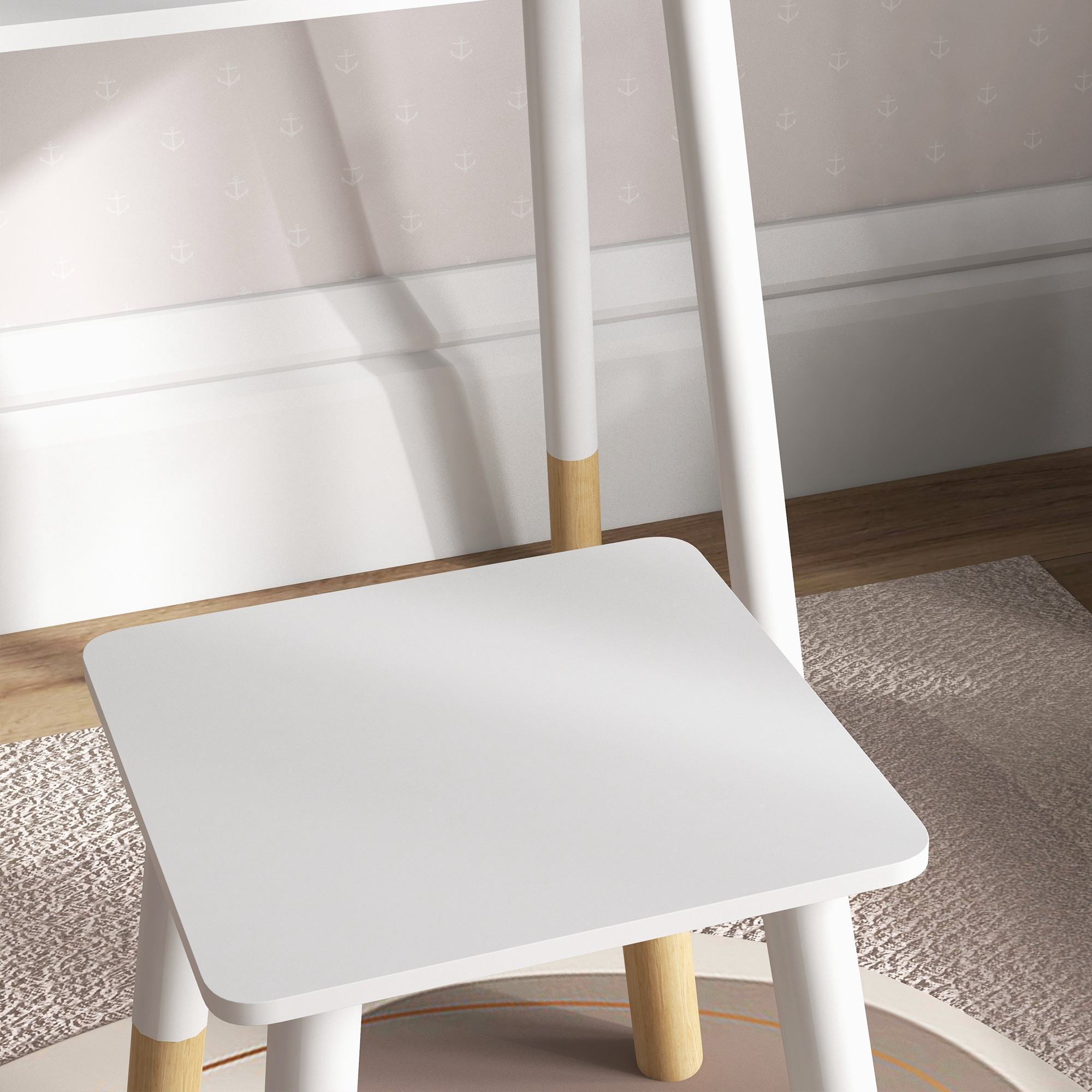 Una mesa blanca con patas de madera está sobre una alfombra. Papel tapiz de anclas en la pared.