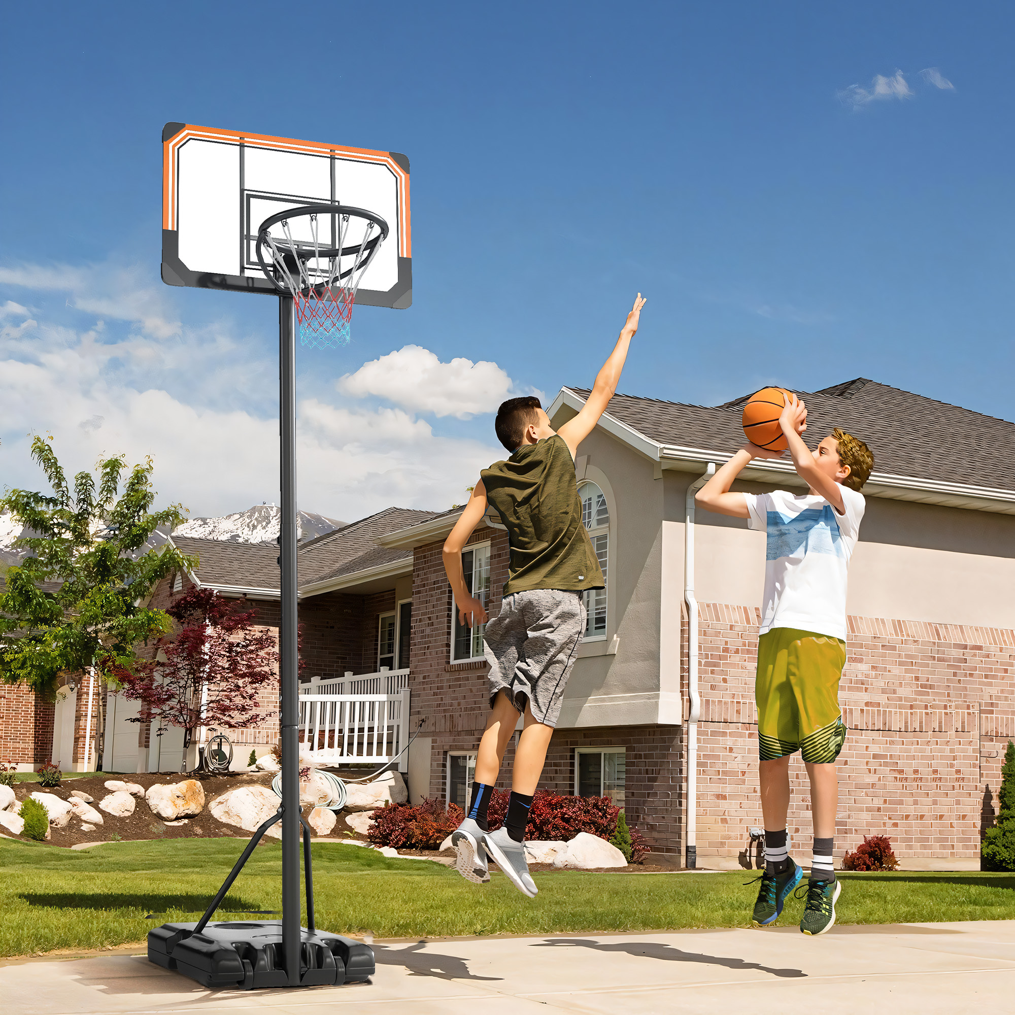 Dos niños juegan baloncesto en una entrada con una casa al fondo.