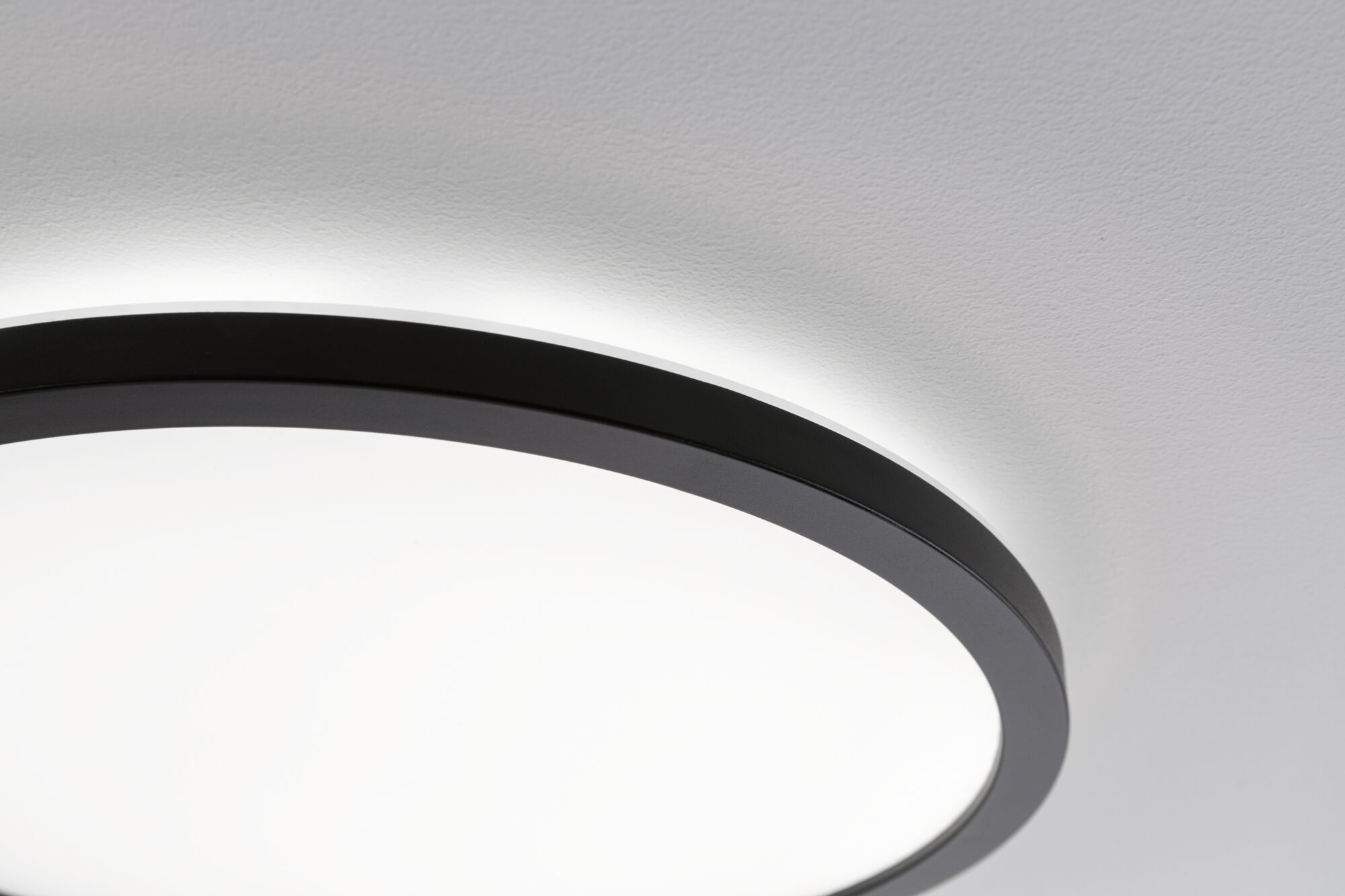 Un moderno ventilatore da soffitto rotondo con bordo nero e centro bianco.