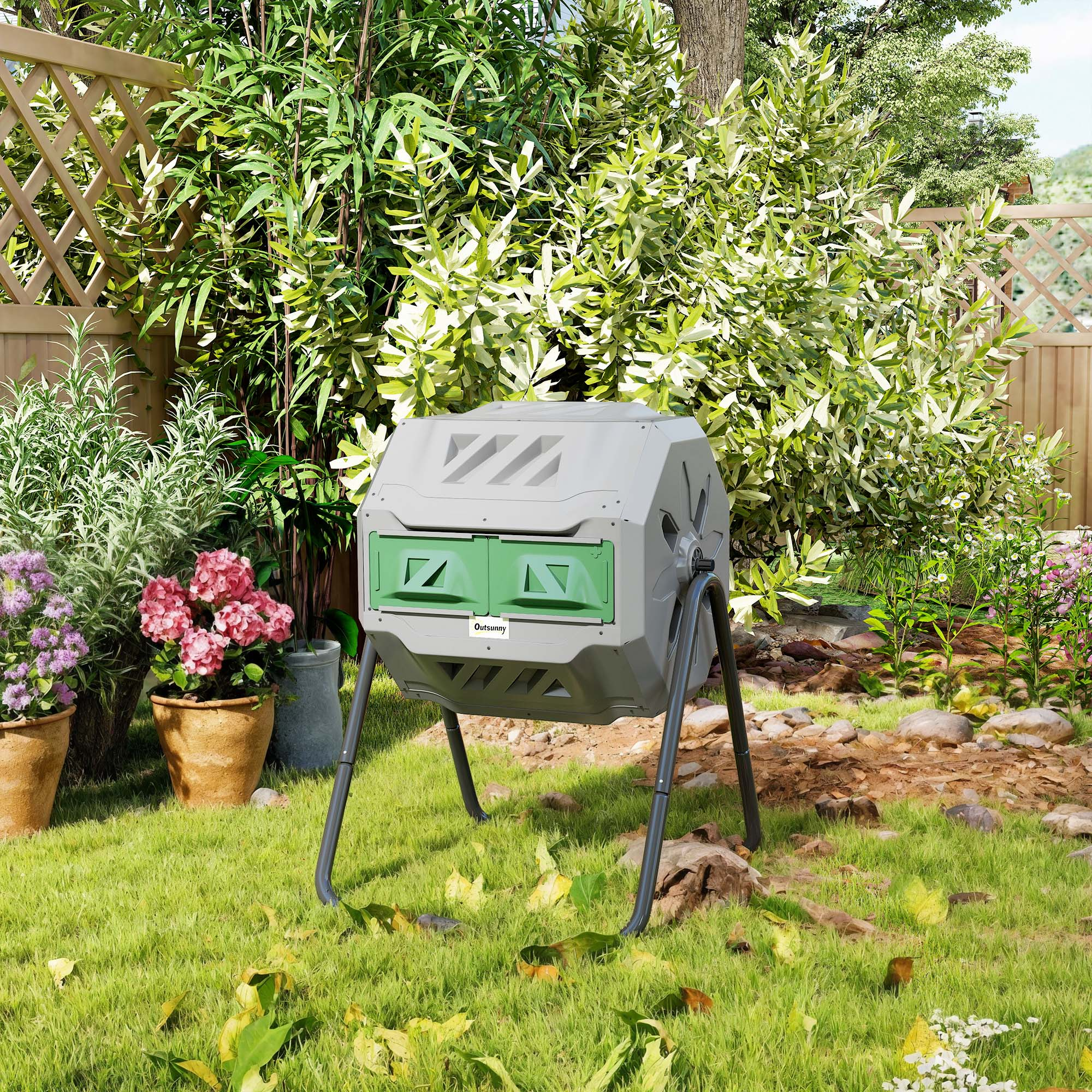 Un compostador gris con puertas verdes se encuentra en un césped.