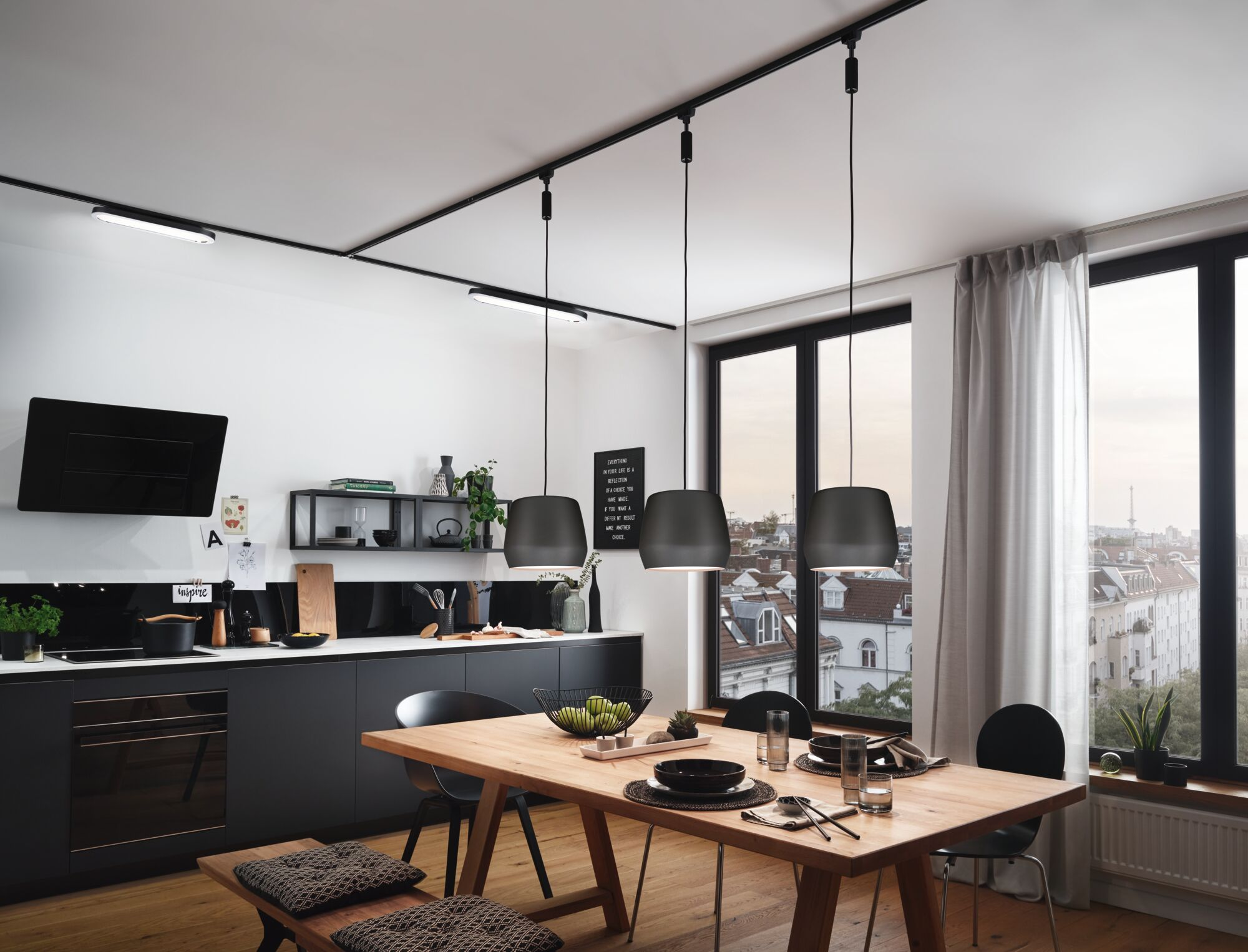 Cucina moderna con zona pranzo, mobili scuri, tavolo in legno e vista sulla città.