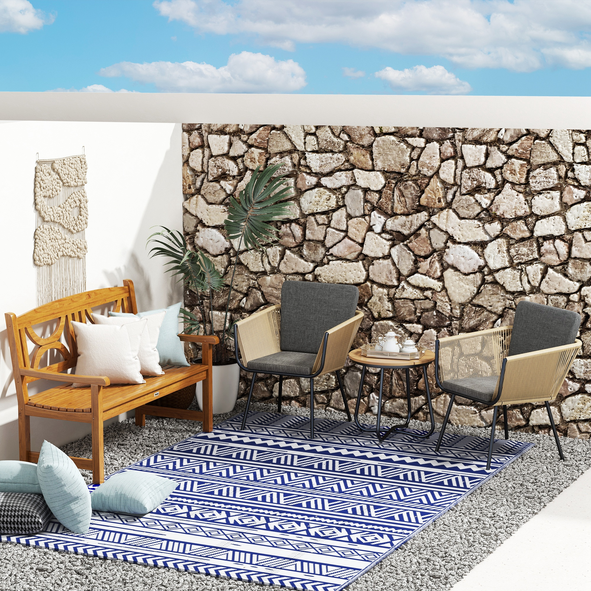 Zona de asientos exterior con banco de madera, sillas, mesa, alfombra y cojines.