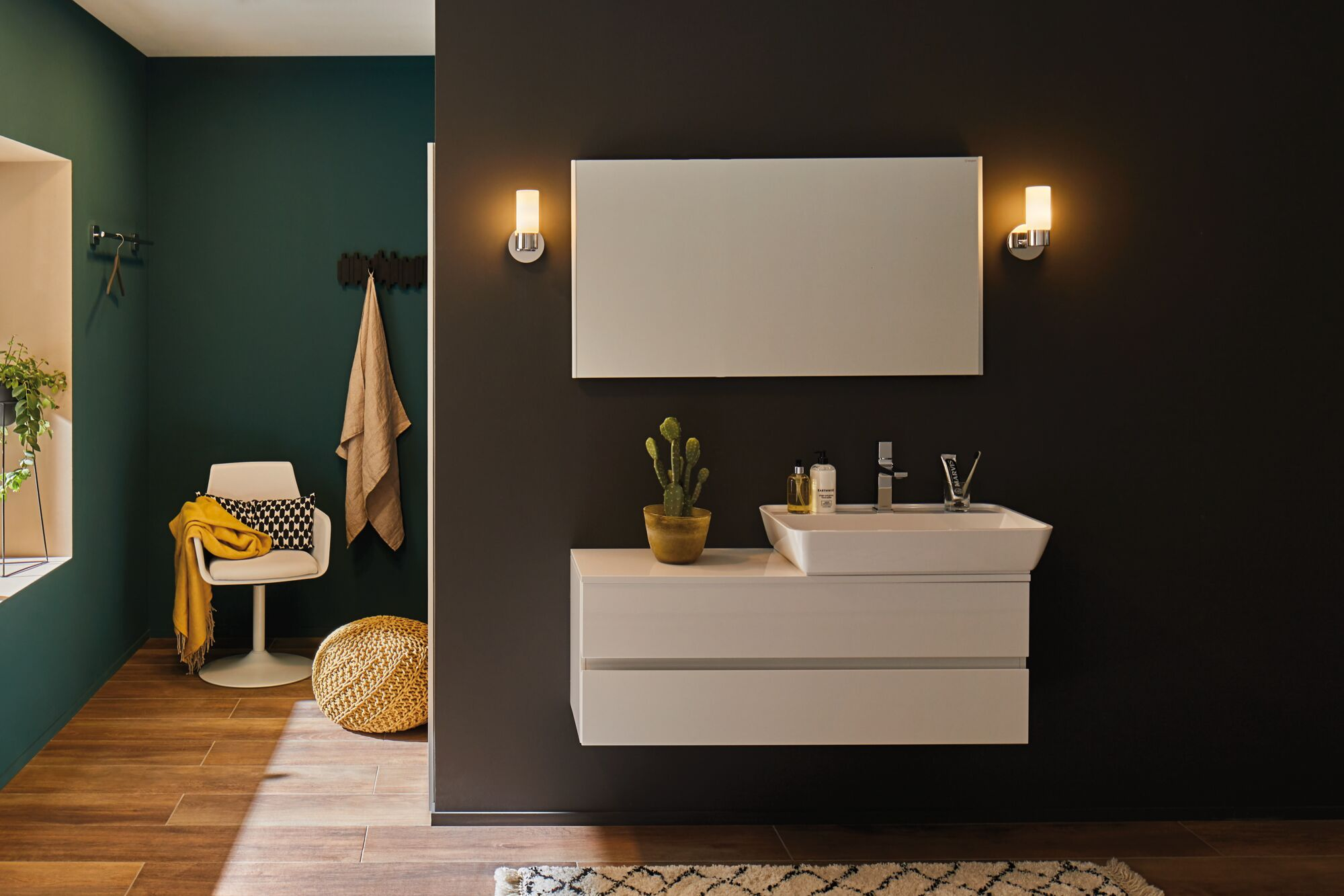 Salle de bain moderne avec lavabo, miroir, éclairage et coin salon.