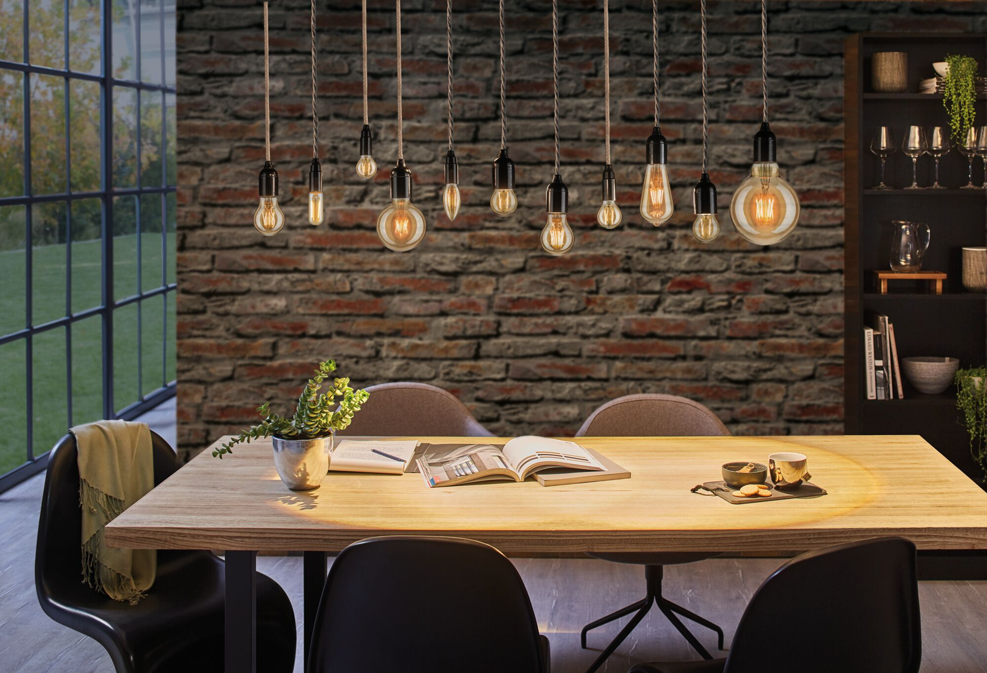 Stół jadalny z miejscami do siedzenia, ceglana ściana i wiszące lampy.