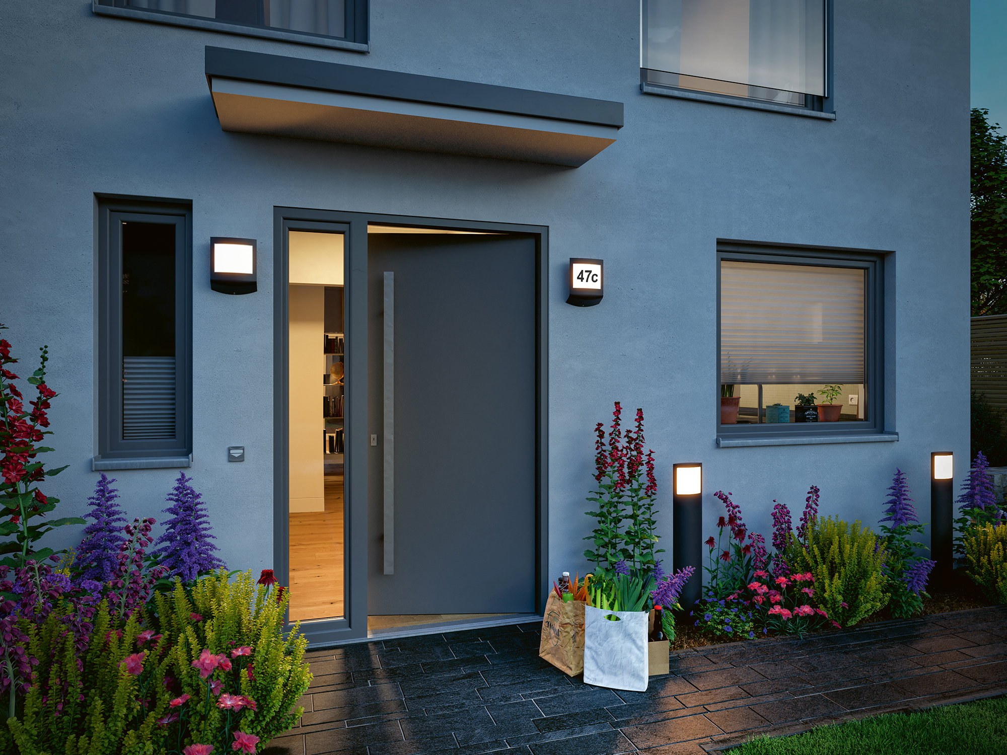 Eingang eines modernen Hauses mit offener Tür, Einkaufstüten und Blumen.
