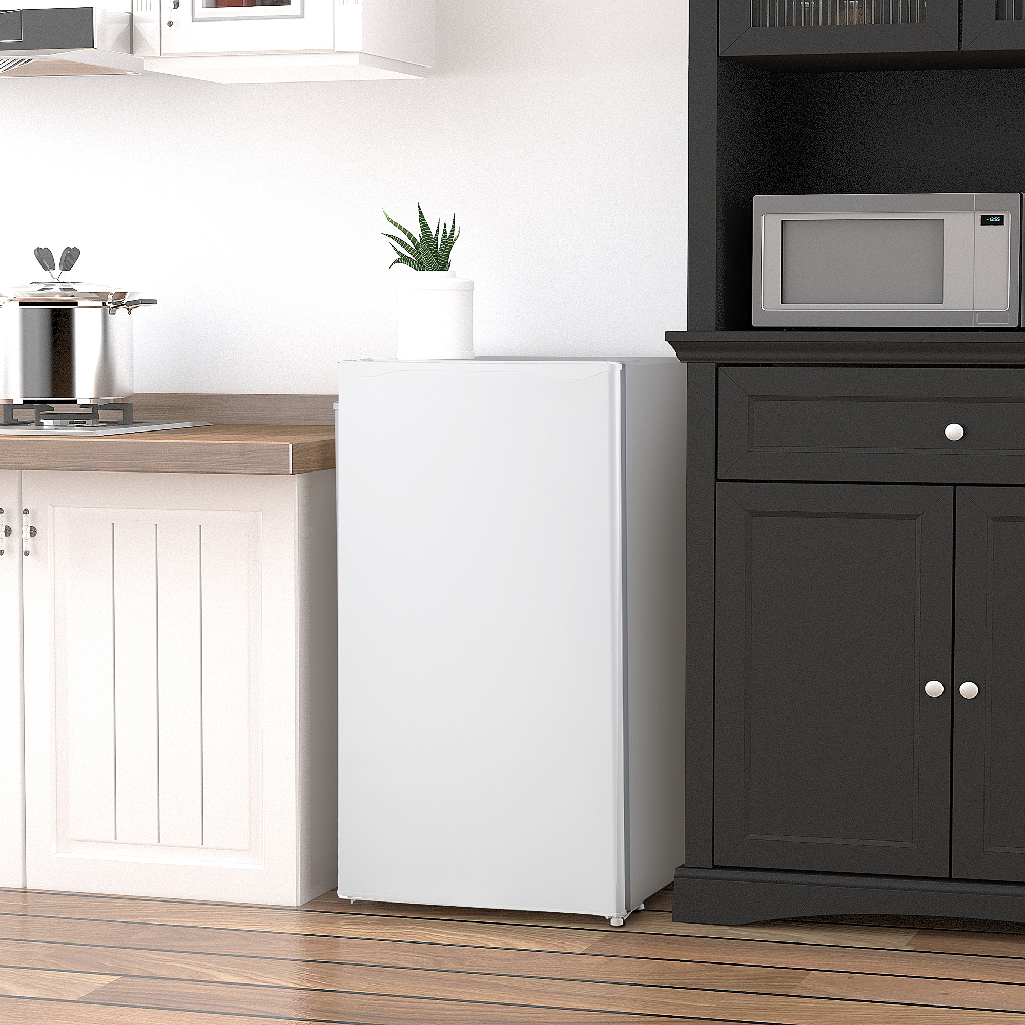 Cocina compacta con frigorífico blanco, olla en estufa, microondas y mueble oscuro.