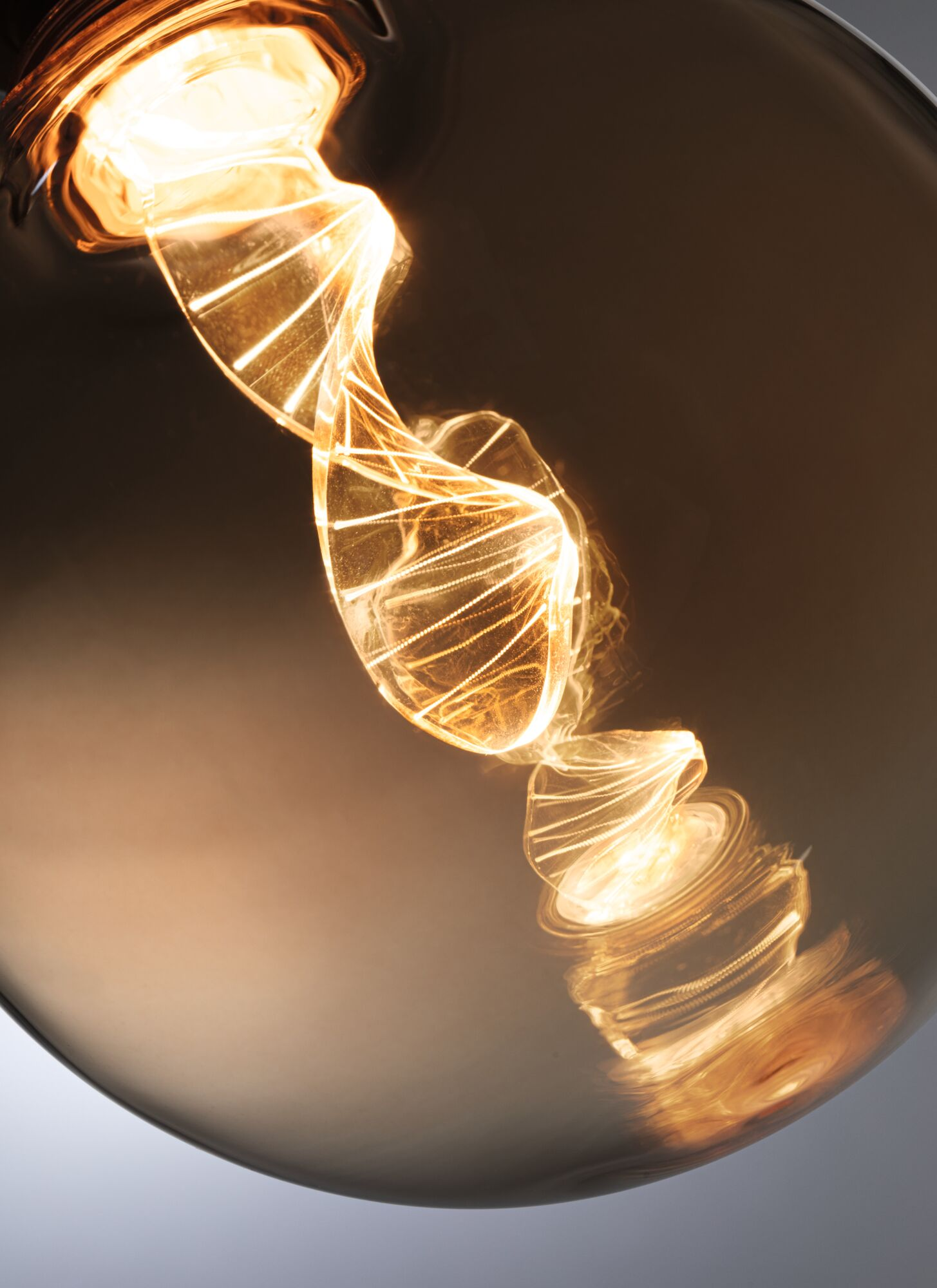 Świecąca żarówka z spiralnym żarnikiem w ciemności.