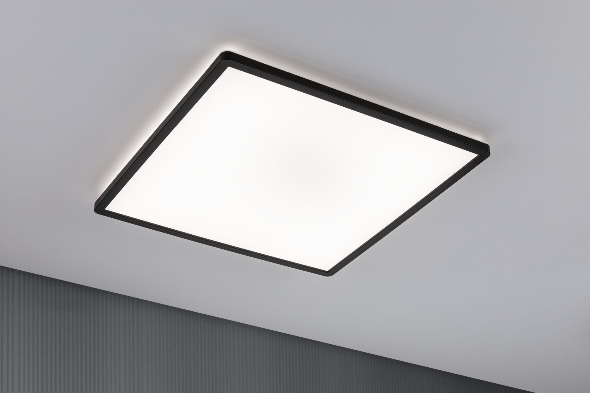 Una plafoniera quadrata con cornice nera su un soffitto bianco.