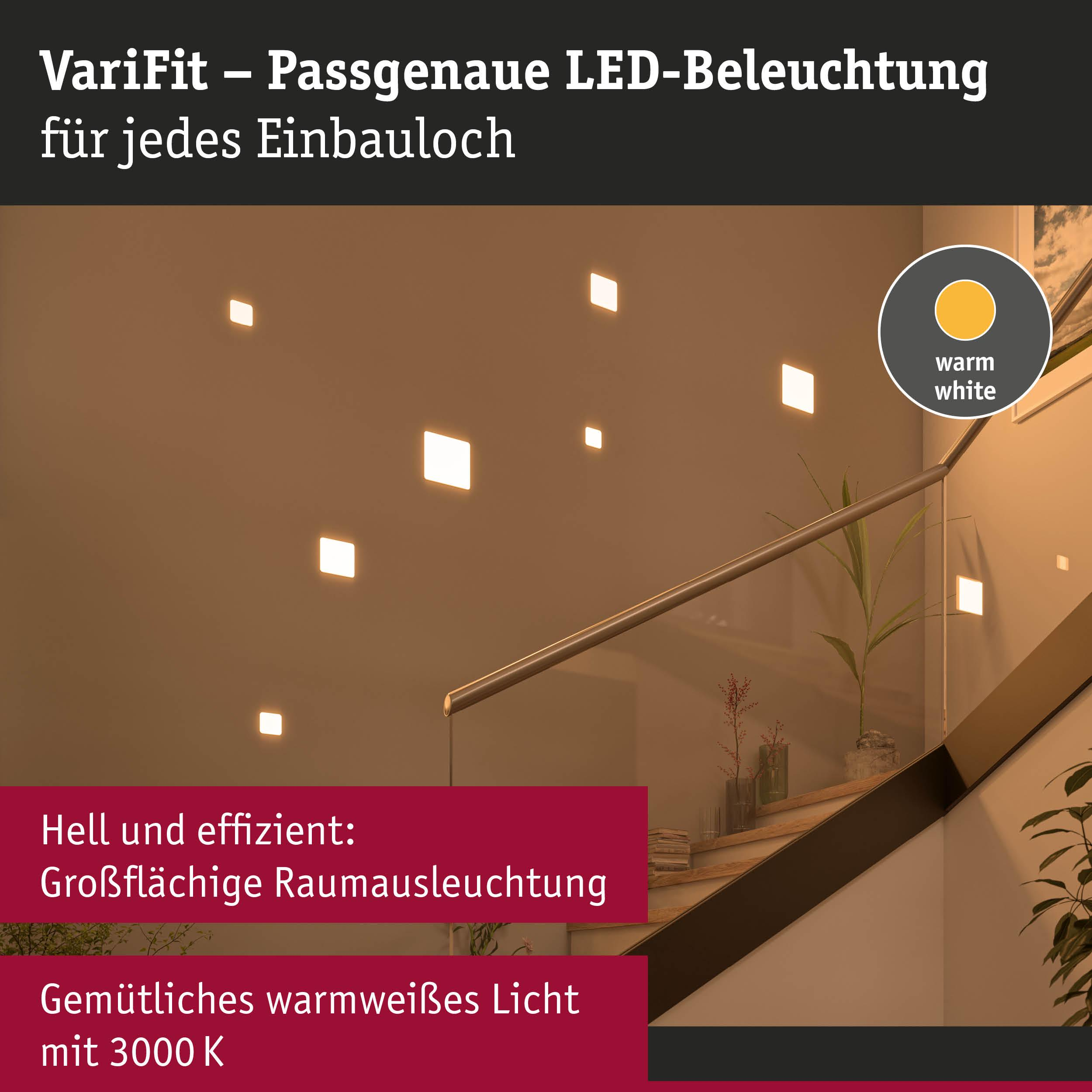 Quadrate leuchten an einer Wand neben einer Treppe mit Geländer.