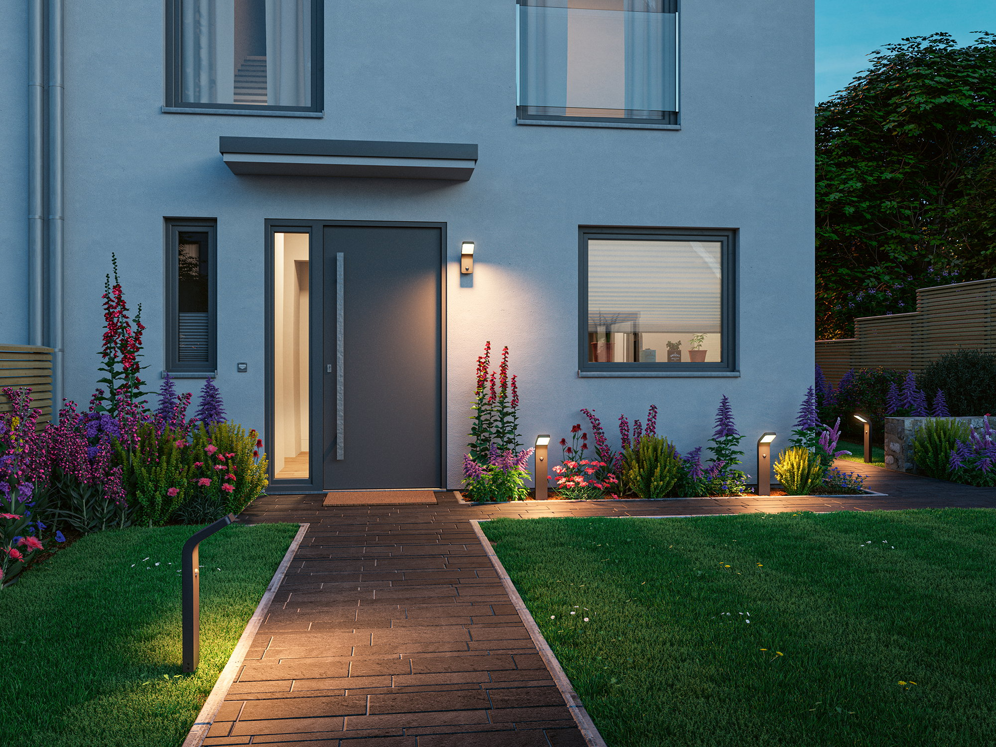 Nowoczesny szary dom ze ścieżką kamienną, oświetloną lampami ogrodowymi.