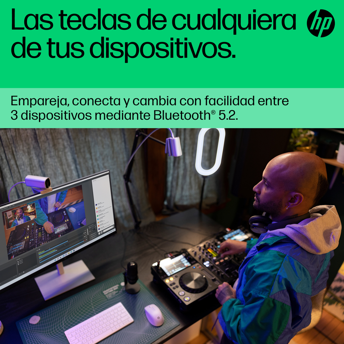 Un hombre con auriculares maneja un equipo de DJ frente a una pantalla.