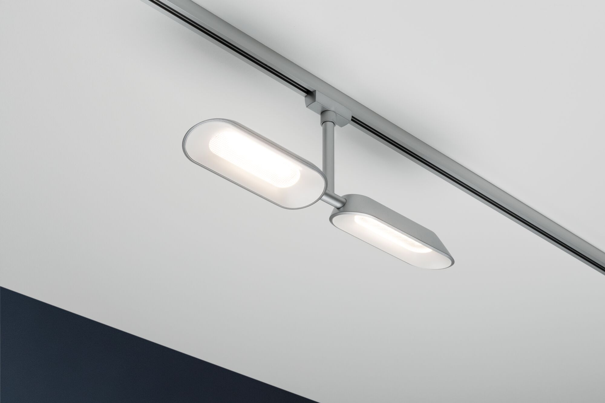 Due luci ovali moderne su un binario montato a soffitto.