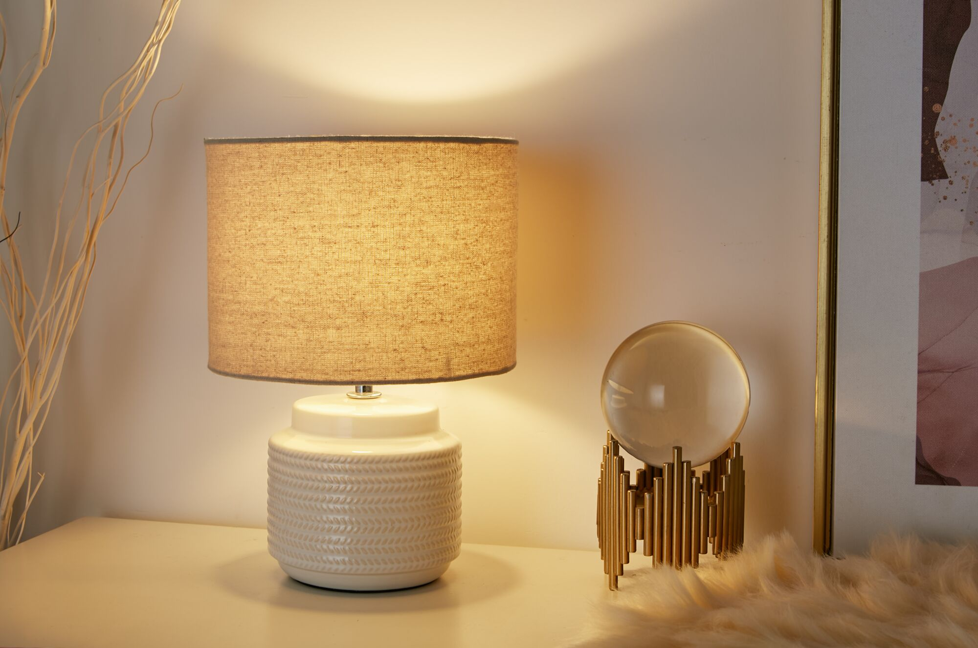 Lampa, szklana kula na złotym stojaku i obraz.