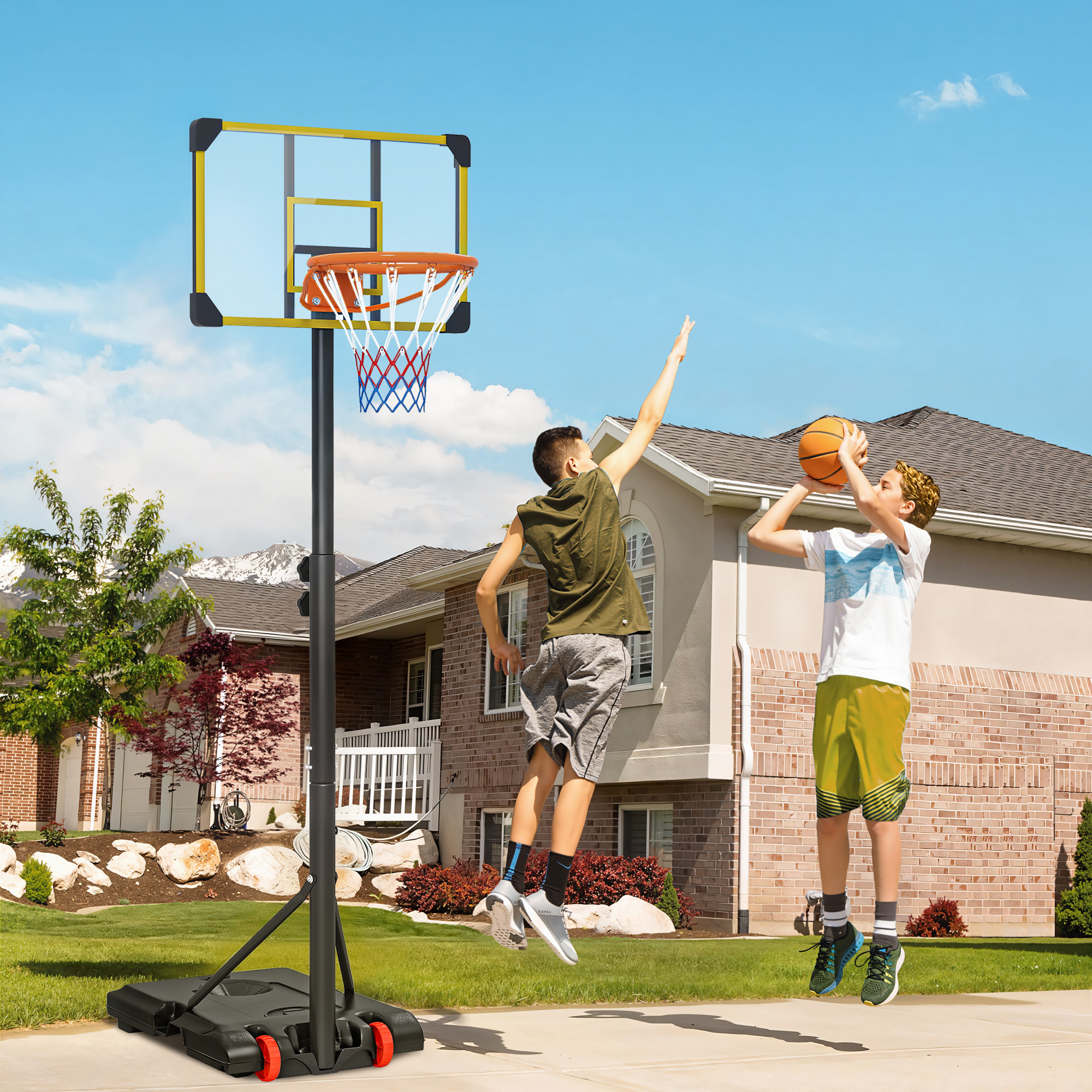 Dos chicos juegan al baloncesto delante de una casa. Uno salta para machacar, el otro lanza.