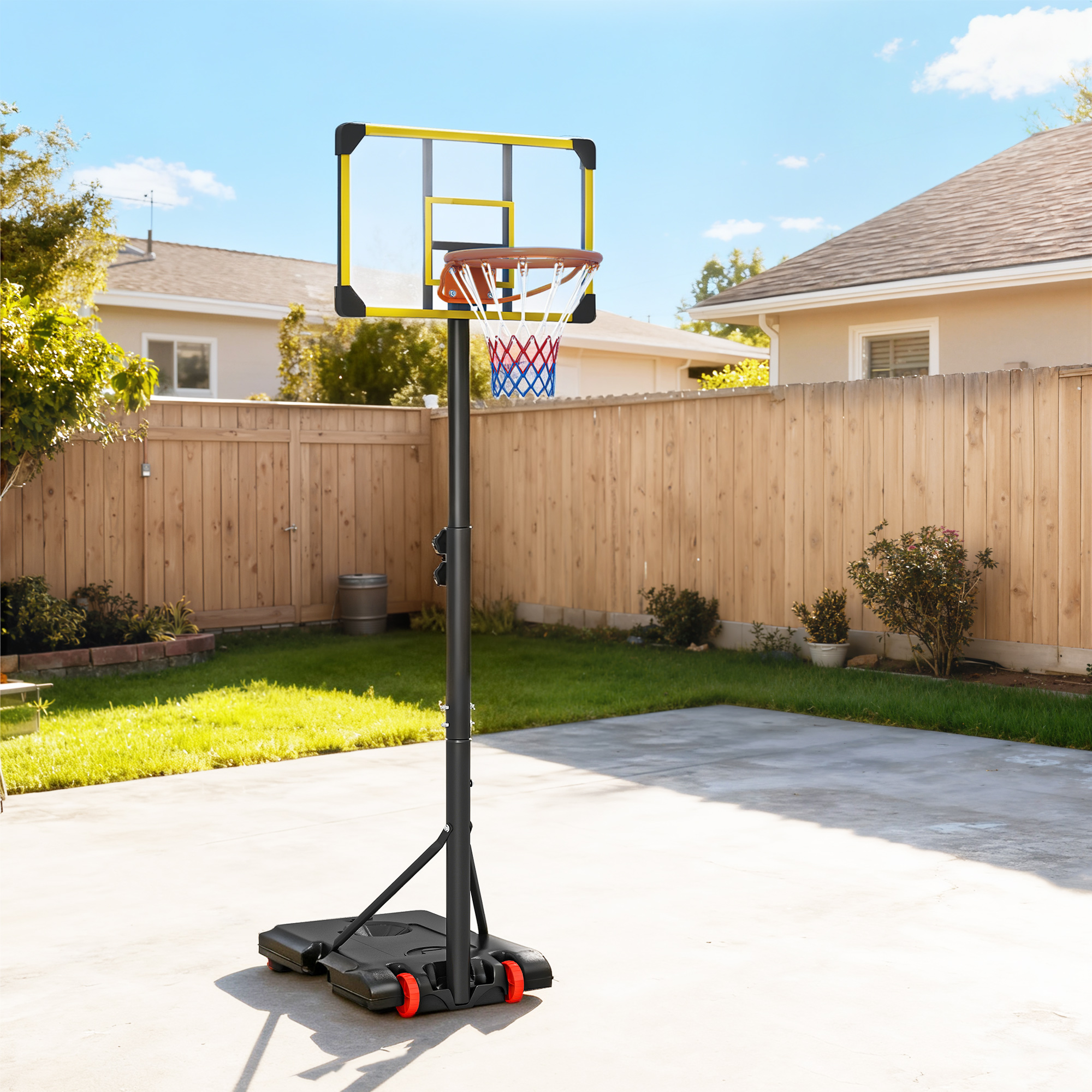 Una canasta de baloncesto portátil con tablero transparente y red roja/azul se encuentra en una cancha pavimentada.
