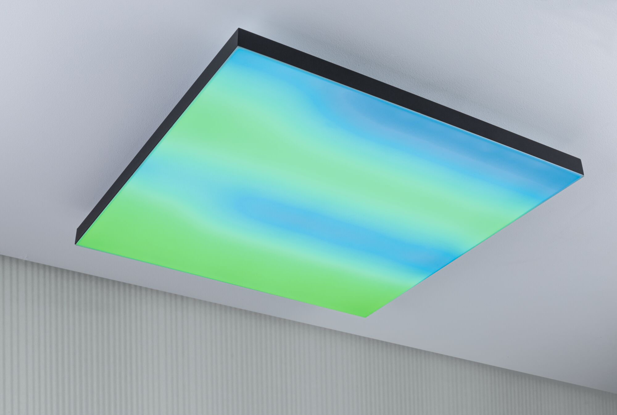 Un pannello luminoso quadrato con sfumatura dal blu al verde, montato su soffitto.