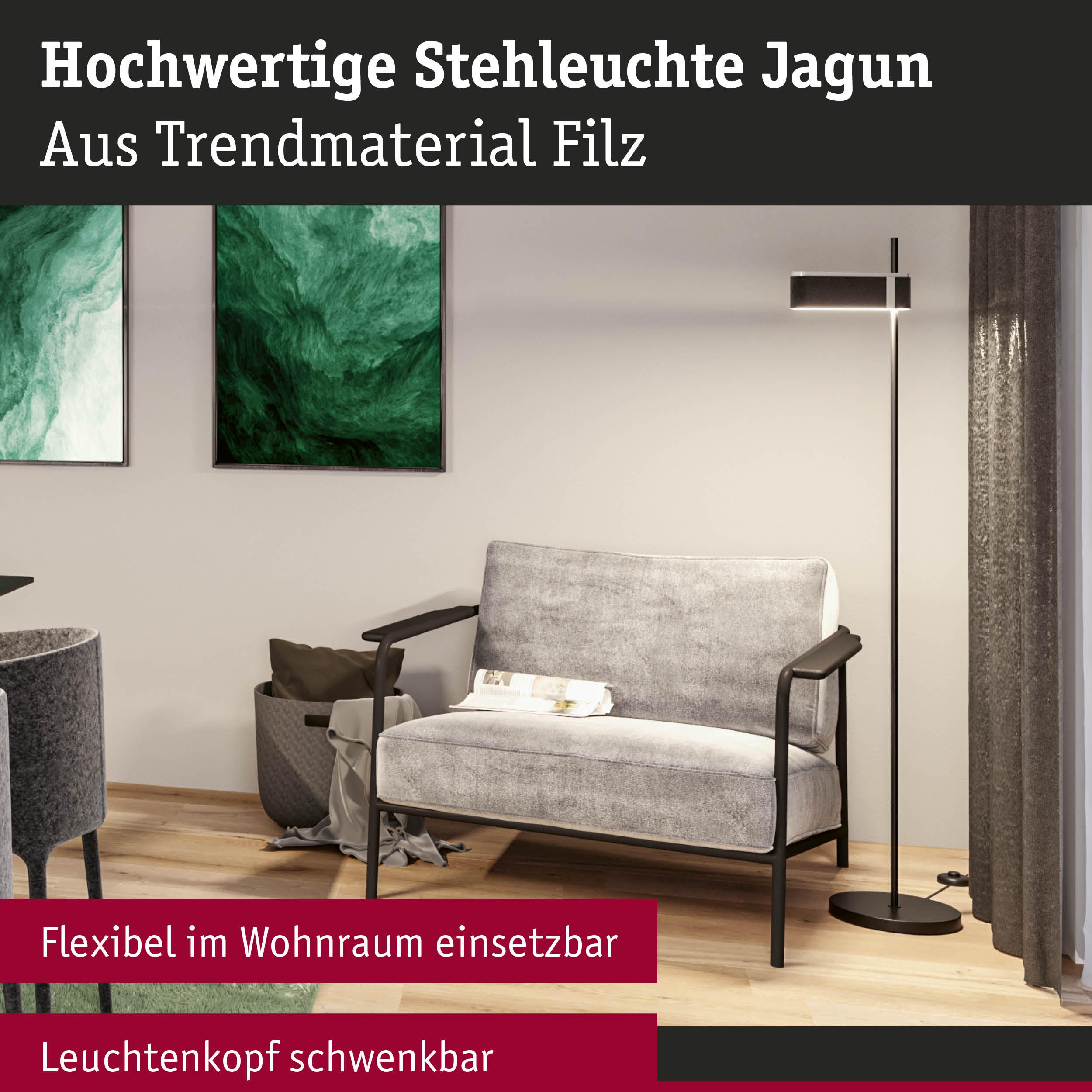 Grauer Sessel mit Zeitung, Stehleuchte, Kunst und Körben.