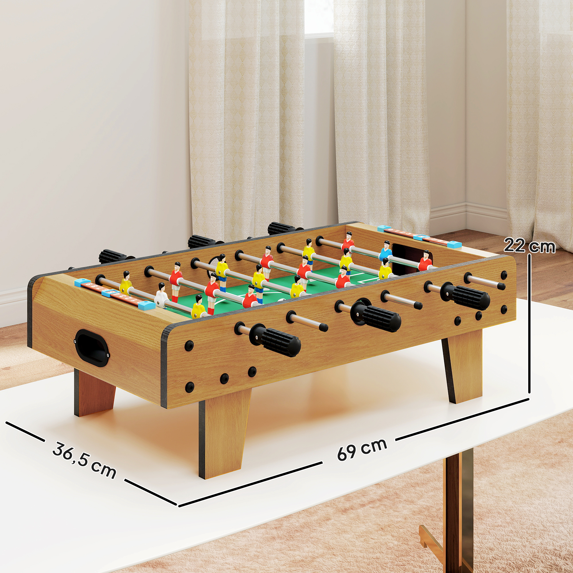 Un futbolín compacto con cuerpo de madera, campo de juego verde y jugadores rojos, amarillos y azules.