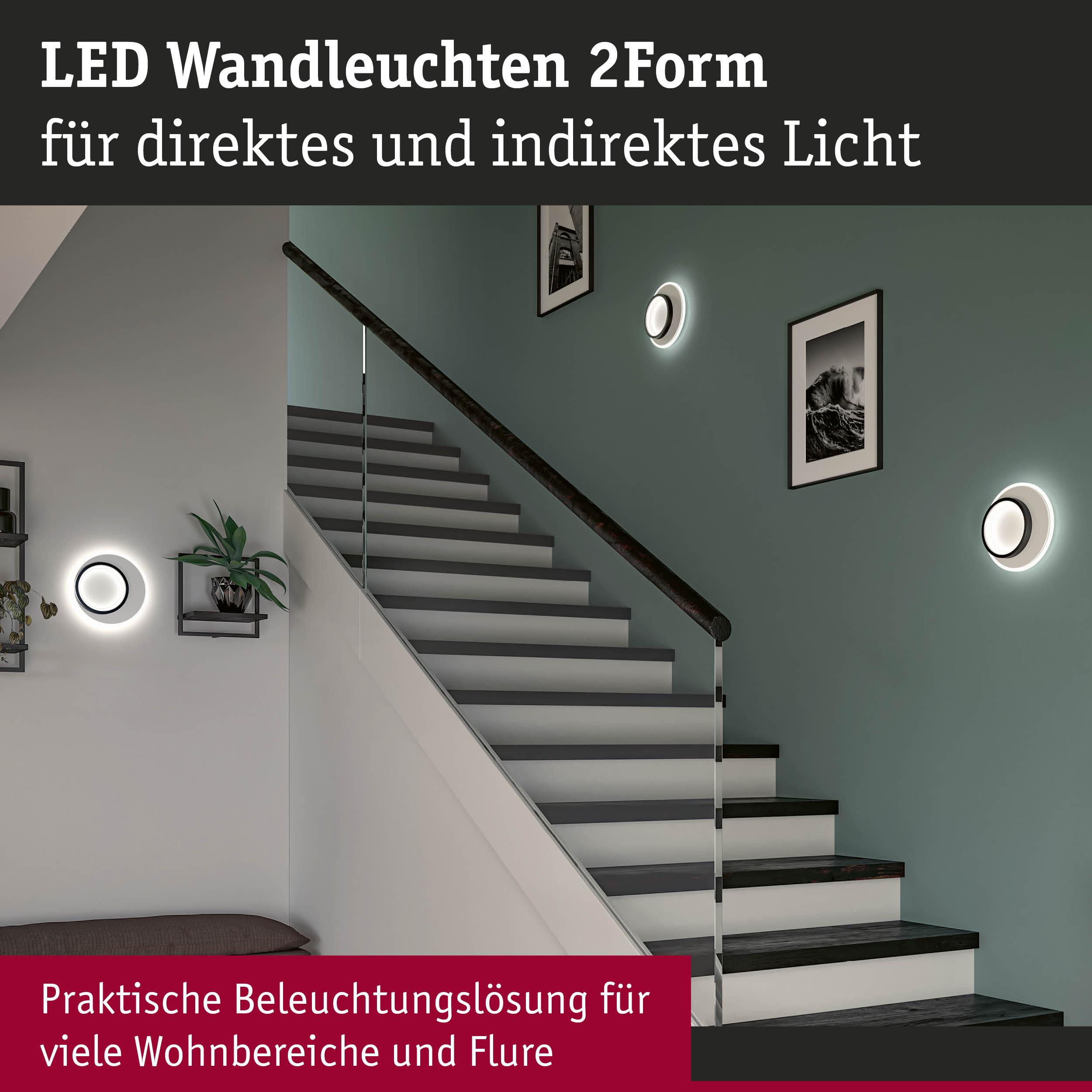 Moderne Treppe mit LED-Wandleuchten und gerahmter Kunst. Dunkles Holzgeländer.
