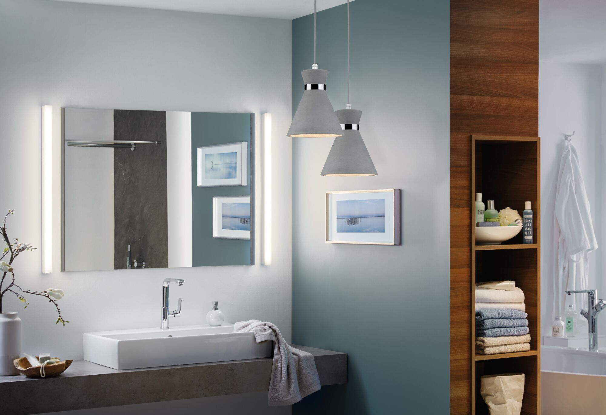 Modernes Badezimmer mit Waschbecken, Spiegel, Hängelampen und Holzregalen mit Handtüchern.